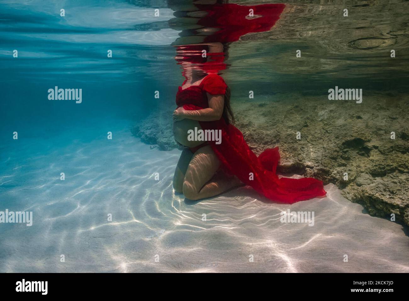 Junge, schwanger Frau, die Baby-Beule für ein Unterwasserfotoschießen zeigt. Stockfoto