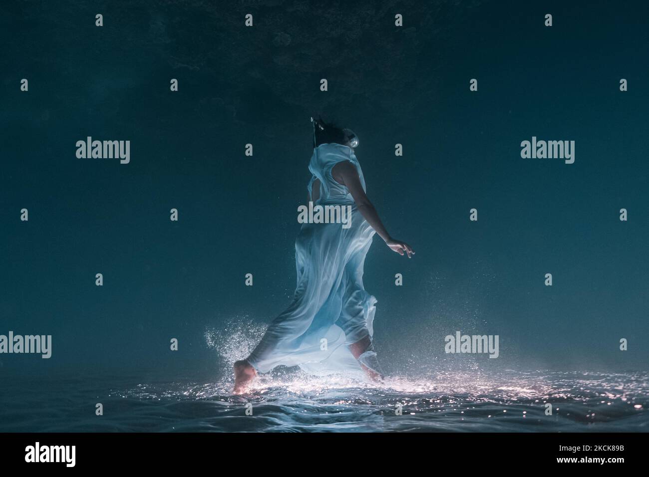 Junge Schwangerische Frau posiert für eine Unterwasserfotositzung. Stockfoto
