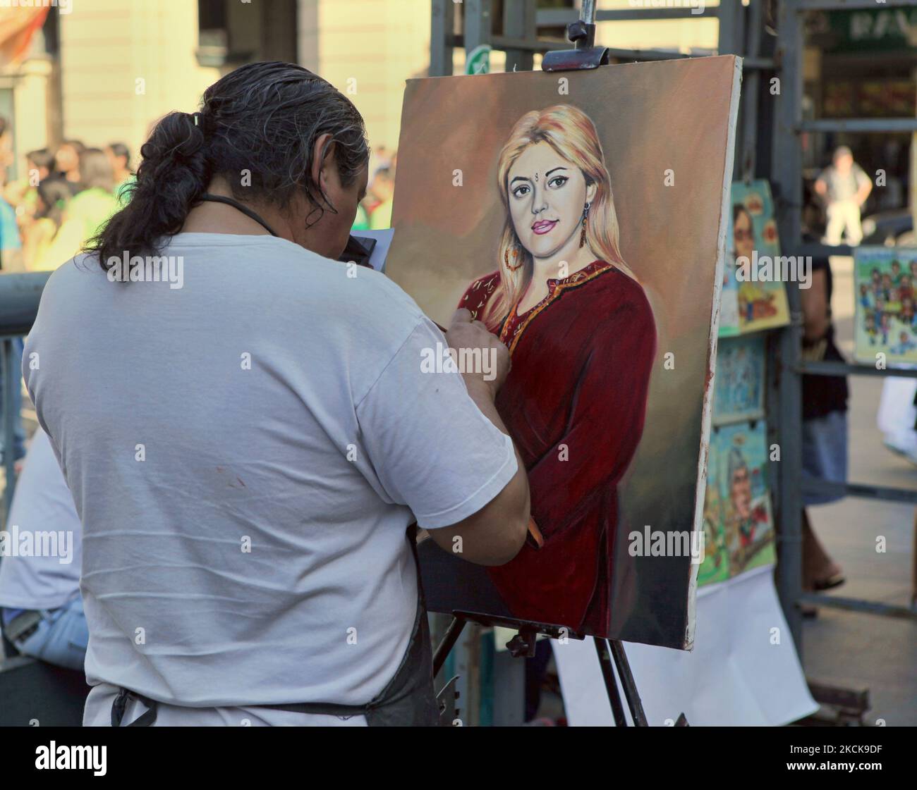 Der Maler malt am 09. März 2010 ein Porträt einer blonden Frau, die ein traditionelles Kaschmiri-Phiran auf der Straße im Zentrum von Santiago, Chile, trägt. (Foto von Creative Touch Imaging Ltd./NurPhoto) Stockfoto