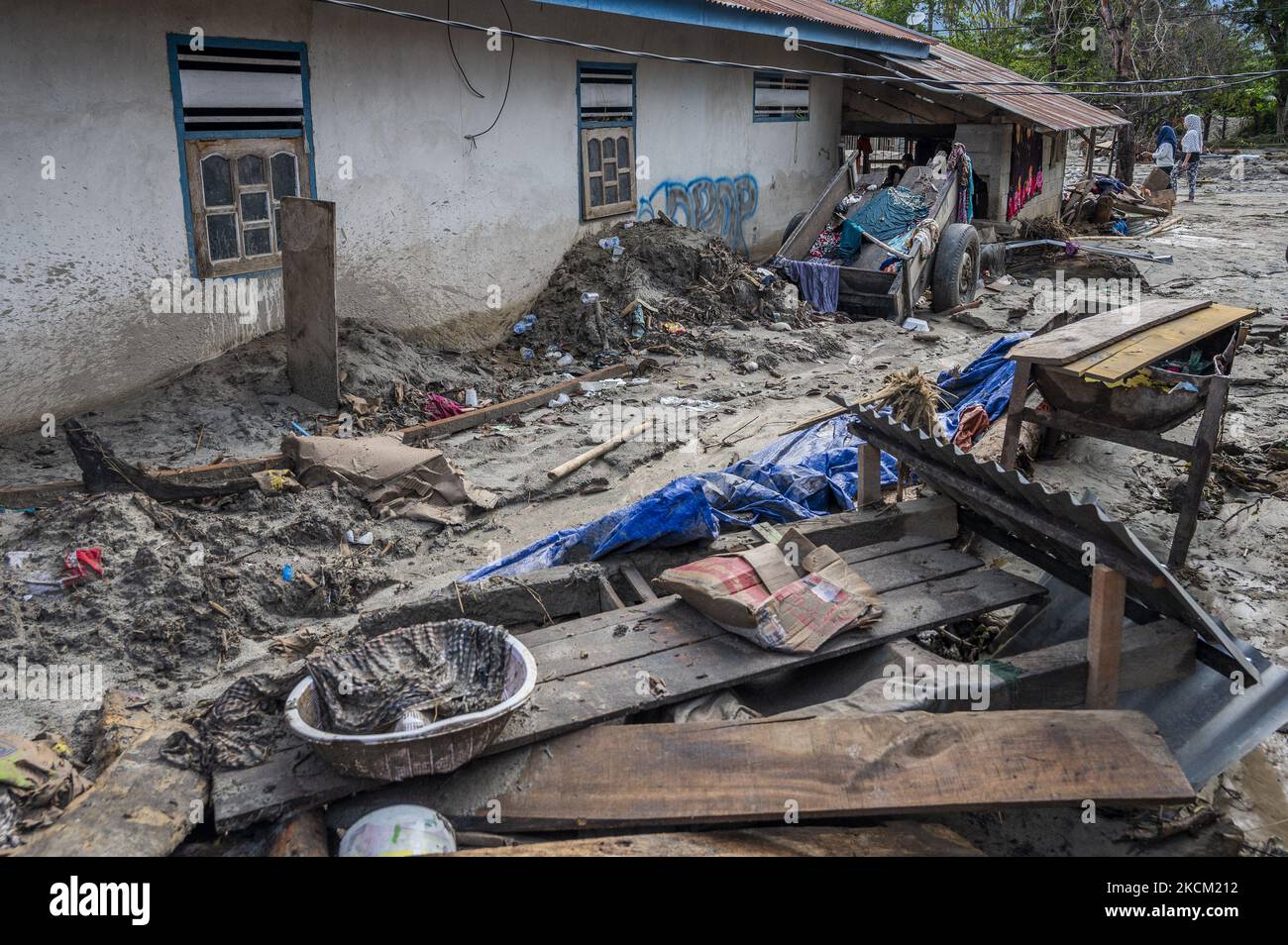 Die Bewohner befinden sich vor ihren Häusern, die nach einer weiteren Sturzflut im Dorf Rogo, Bezirk South Dolo, Sigi Regency, Provinz Central Sulawesi, Indonesien, am 6. September 2021 in Schlamm und Sand vergraben wurden. Nachdem das Dorf am Samstag (29. August 2021) von Sturzfluten heimgesucht wurde, wurde es am Sonntag (5. September 2021) in der Nacht erneut von einer Sturzflut heimgesucht, die dazu führte, dass Dutzende von Häusern in Schlamm getaucht wurden und Hunderte von Bewohnern an sichere Orte zurückkehrten. Die Sturzflut im Dorf war das vierte Mal seit November 2020. Die Topographie des Gebiets am foo Stockfoto