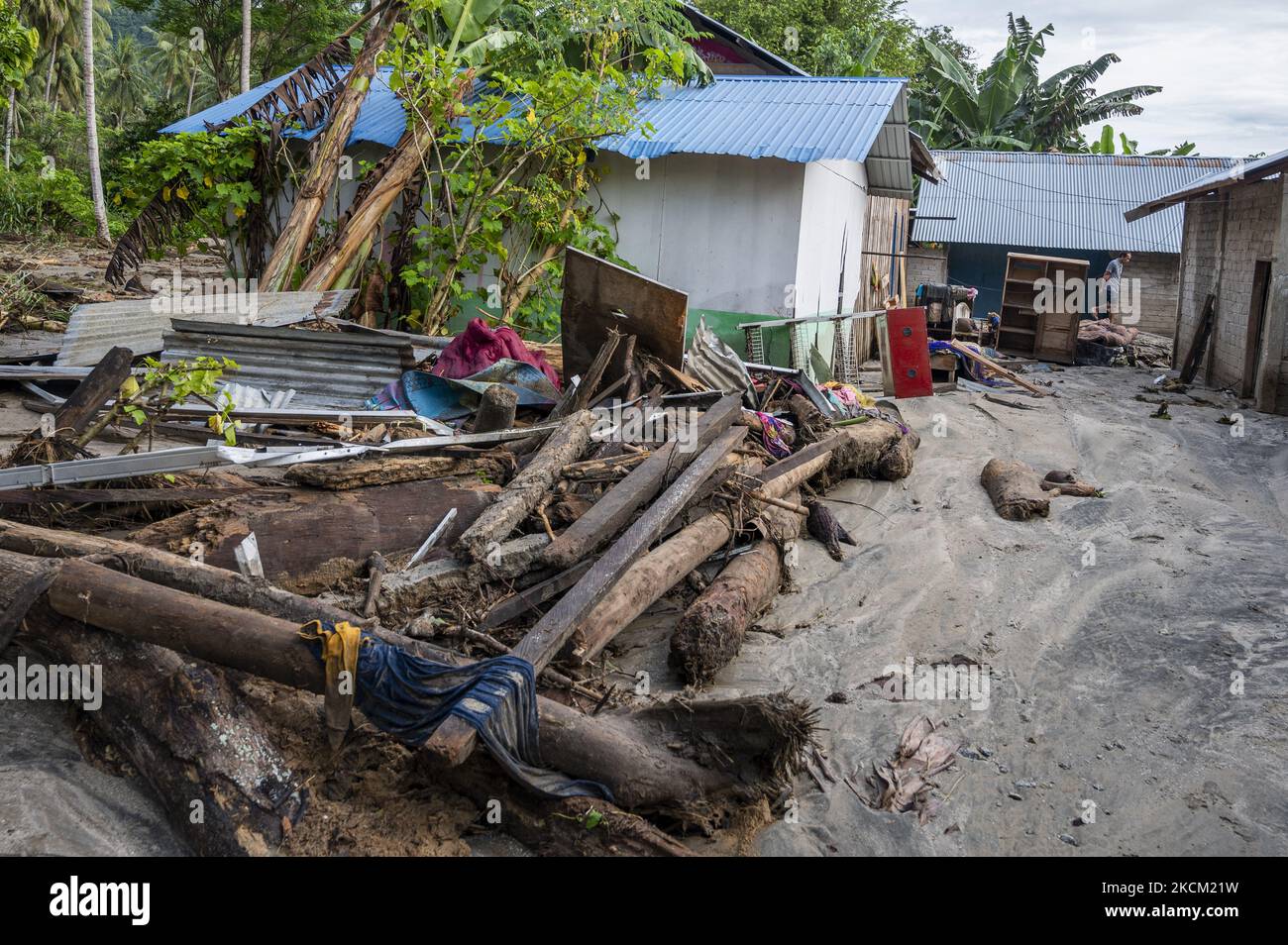Die Bewohner befinden sich vor ihren Häusern, die nach einer weiteren Sturzflut im Dorf Rogo, Bezirk South Dolo, Sigi Regency, Provinz Central Sulawesi, Indonesien, am 6. September 2021 in Schlamm und Sand vergraben wurden. Nachdem das Dorf am Samstag (29. August 2021) von Sturzfluten heimgesucht wurde, wurde es am Sonntag (5. September 2021) in der Nacht erneut von einer Sturzflut heimgesucht, die dazu führte, dass Dutzende von Häusern in Schlamm getaucht wurden und Hunderte von Bewohnern an sichere Orte zurückkehrten. Die Sturzflut im Dorf war das vierte Mal seit November 2020. Die Topographie des Gebiets am foo Stockfoto