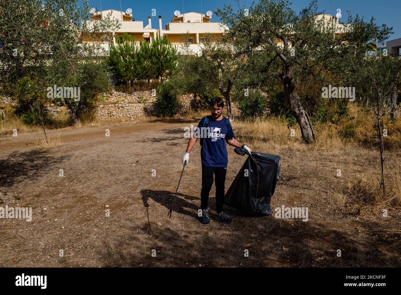 Ein Freiwilliger der Terrae Association reinigt die grüne Lunge der Stadt Lama Martina während des Nationalen Plastic Free Day in Molfetta am 26. September 2021. Jedes Jahr erreichen 12 Millionen Tonnen Plastik weltweit Meere, das entspricht einem LKW Müll pro Minute, und 1,5 Millionen Tiere, vor allem Meerestiere, sterben an Plastik. Plastikverschmutzung ist jetzt ein Problem, das wir nicht mehr ignorieren können. Seit mehr als 2 Jahren engagiert sich der Verein Plastic Free für dieses Thema und organisiert dank seines Netzwerks von Kontakten und sozialen Kanälen jedes Jahr 2 nationale Veranstaltungen, in denen jeweils Stockfoto