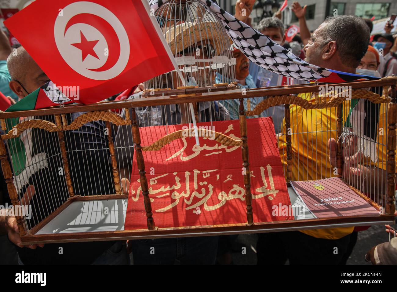 Ein Demonstranten hält einen Käfig mit einem Plakat, auf dem auf Arabisch die Verfassung der Republik Tunesien steht, während einer Demonstration, die am 26. September 2021 auf der Avenue Habib Bourguiba in Tunis, Tunesien, stattfand, um gegen das zu protestieren, was Tausende von Demonstranten einen Putsch nannten, Unter Bezugnahme auf die neuen Sondermaßnahmen, die vom Präsidenten Tunesiens erlassen und im Amtsblatt veröffentlicht wurden, verwies Kais Saied. Ein paar Tage zuvor kündigte Kais Saied die Fortsetzung des Einfrierens des Parlaments und die Verkündung außergewöhnlicher Maßnahmen für die Ausübung der gesetzgebenden Gewalt und die von Exekutive an. H Stockfoto