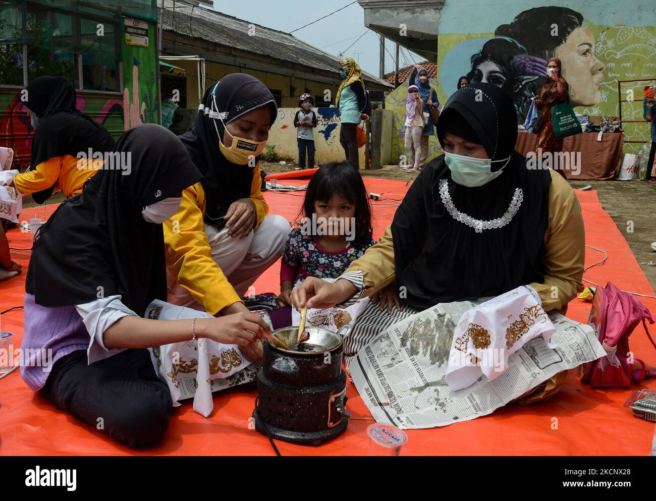 Frauen und Kinder schaffen Batik, während Indonesier am 02. Oktober 2021 in Bogor, West-Java, Indonesien, den nationalen Batik-Tag feiern. Die UNESCO bezeichnete die Batik als Meisterwerk des mündlichen und immateriellen Kulturerbes der Menschheit. (Foto von Adriana Adie/NurPhoto) Stockfoto