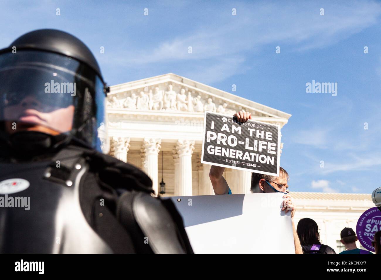 Ein Pro-Life-Gegenproter hält ein Schild hinter einem Polizeibeamten des Kapitols in Aufruhr, als der Frauenmarsch zum Abtreibungsgericht den Obersten Gerichtshof der USA verabschiedet. Die Demonstranten fordern von der US-Regierung, die reproduktiven Rechte von Frauen und den Zugang zu Abtreibungen landesweit zu schützen. Konkret fordern sie den Kongress auf, das Frauengesundheitsschutzgesetz (WHPA) und JEDES Gesetz zu verabschieden, das den Zugang zu Abtreibungen garantiert und eine Versicherung verlangt. Am 2. Oktober finden bundesweit mehr als 600 Satellitenproteste statt. Die Ereignisse sind teilweise eine Reaktion auf restriktive Anti-Abtreibungsgesetze, die kürzlich verabschiedet wurden Stockfoto