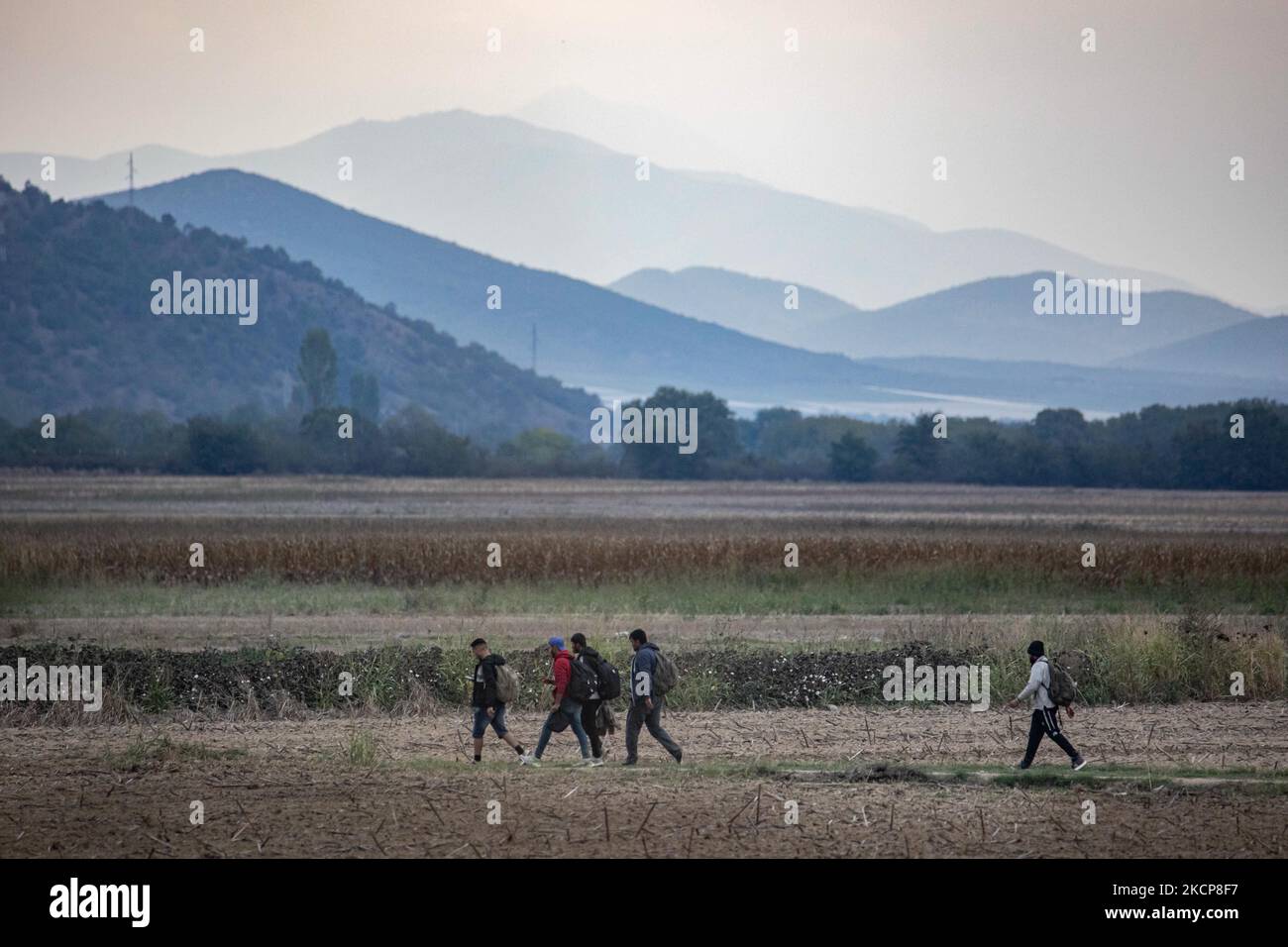 Asylbewerber versuchen, die griechisch-nordmazedonischen Grenzen zu überqueren, um der 2015-2016 während der syrischen Flüchtlingskrise berühmten Balkanroute zu folgen, von Idomeni, Griechenland, nach Gevgelija, Nord-Mazedonien, den Bahnschienen und dem Bahnhof folgend, um dann Mittel- und Nordeuropa zu erreichen. Flüchtlinge und Migranten werden auf den Feldern auf der griechischen Seite mit den nordmazedonischen Bergen im Hintergrund vor dem Zaun, der die beiden Länder trennt, gesehen und versuchen, die Grenzen zu erreichen und zu passieren. Die kleinen Gruppen sind überwiegend männlich dominiert aus Afghanistan, Neuankömmlinge, die ihre Reise nach hinten begannen Stockfoto