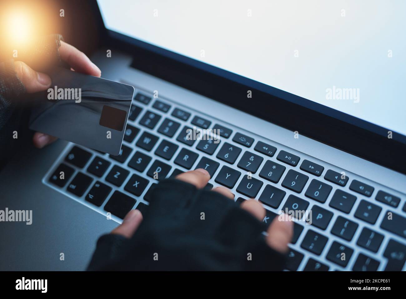 Es ist jetzt alles meine. Ein nicht erkennbarer Hacker, der einen Laptop benutzt, um in ein Kreditkonto zu hacken. Stockfoto
