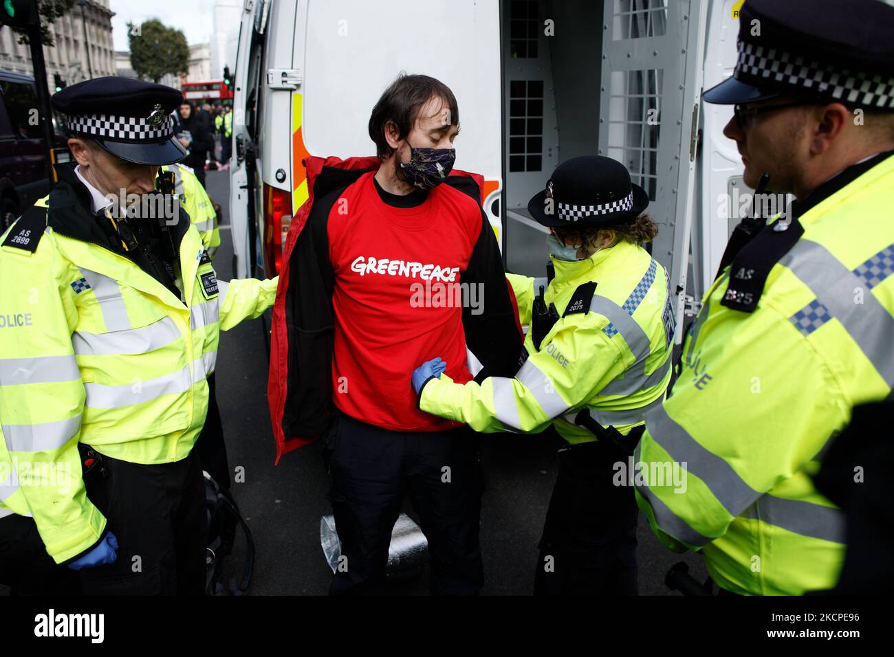 Polizeibeamte verhaften einen Greenpeace-Aktivisten, der am 11. Oktober 2021 vor den Toren der Downing Street in Whitehall in London, England, von einer „Sperre“ an eine Öltrommel befreit wurde. Der Protest, zu dem die Aktivisten auch eine ölverschmierte Scheinstatue des britischen Premierministers Boris Johnson brachten, wurde inszeniert, um gegen die vom Energieunternehmen Siccar Point von den britischen Behörden beantragte Genehmigung für Bohrungen auf dem Ölfeld Cambo in der Nordsee zu protestieren. (Foto von David Cliff/NurPhoto) Stockfoto