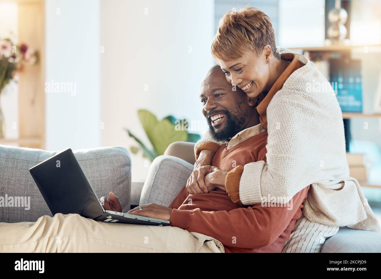 Schwarzes Paar, Laptop und Umarmung zusammen mit Technologie zu Hause, sehen einen Film oder Videoanruf mit 5G Netzwerk. Schwarzer Mann, schwarze Frau und Ausgaben Stockfoto