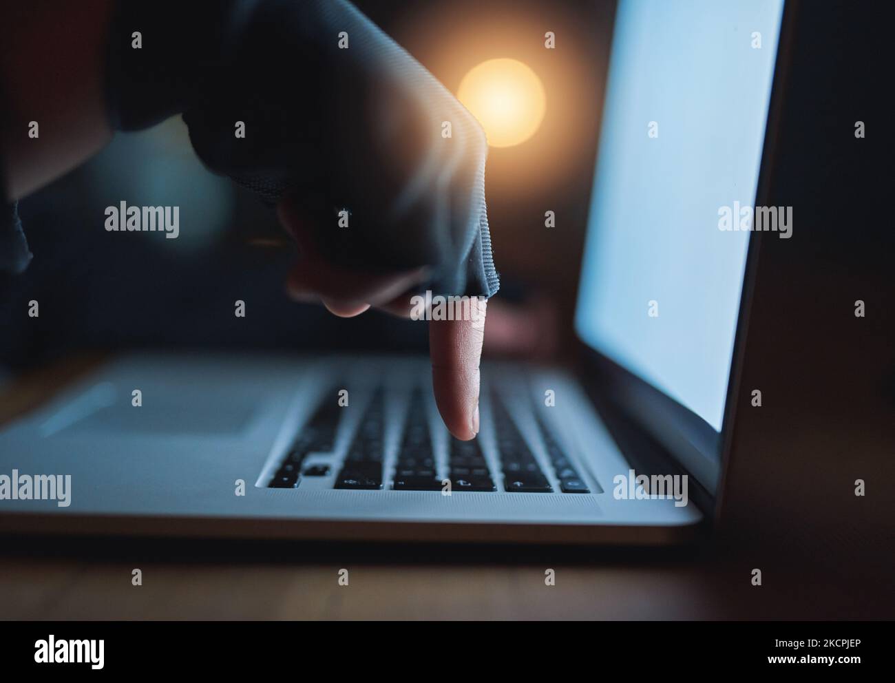 Seien Sie vorsichtig, was Sie online teilen. Ein nicht erkennbarer Hacker mit einem Laptop im Dunkeln. Stockfoto