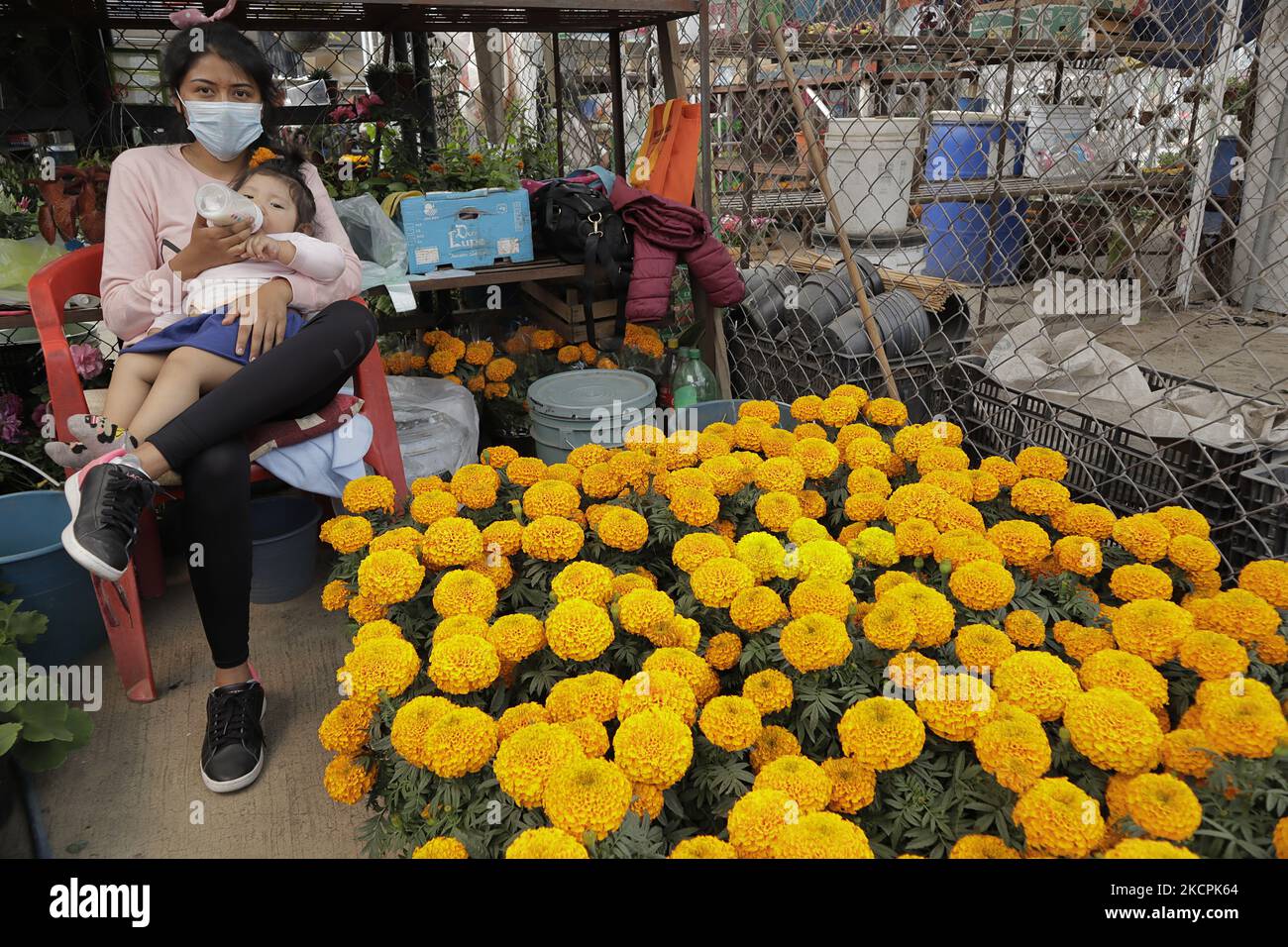 Eine Frau füttert ihr Baby auf dem Acuexcomatl-Markt in San Luis Tlaxialtemalco, Xochimilco, Während der Eröffnung des Verkaufs von Flor de Cempasúchitl im Hinblick auf die gesundheitliche Notlage durch COVID-19 und die epidemiologische Ampel in der Hauptstadt am Vorabend der Feierlichkeiten zum Tag der Toten in Mexiko am 1. Und 2. November. (Foto von Gerardo Vieyra/NurPhoto) Stockfoto