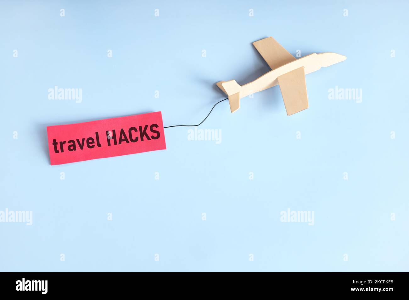 Reise-Hacks und Tipps Konzept. Holzflugzeug, das mit rotem Schild fliegt. Stockfoto