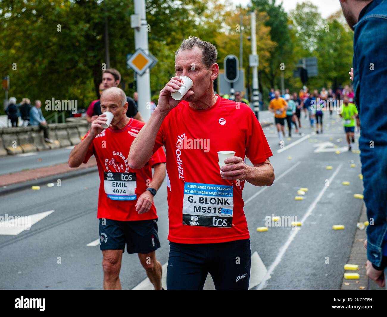 Zwei Läufer machen am 17.. Oktober 2021 auf den letzten Kilometern des TCS Amsterdam Marathons eine Pause und trinken Wasser. (Foto von Romy Arroyo Fernandez/NurPhoto) Stockfoto