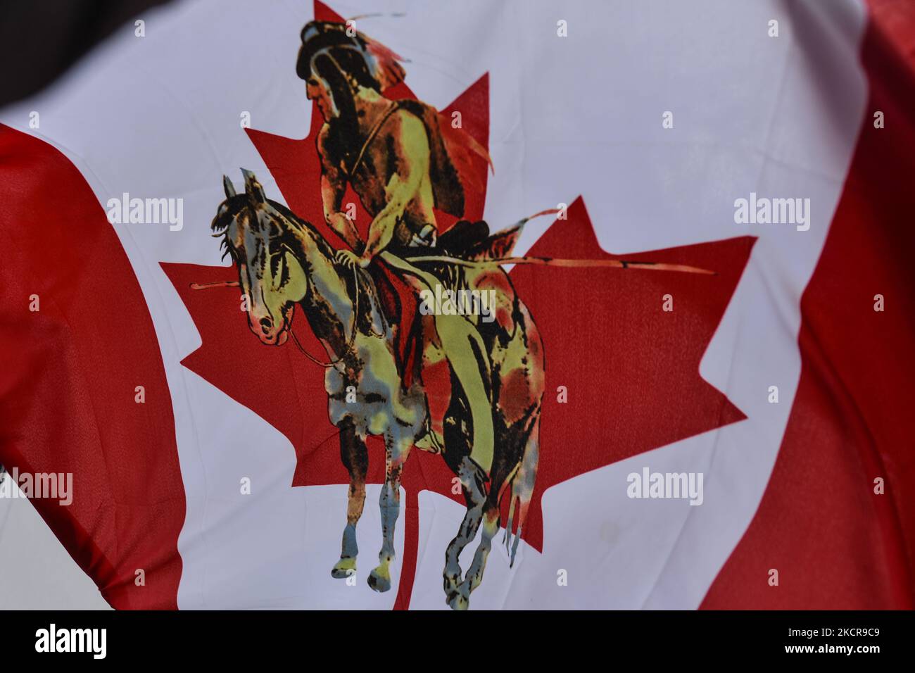Eine modifizierte kanadische Flagge mit einem Bild eines First Nations-Mitglieds in der Mitte, gesehen in einem „Einwohnerlager“, das aus fünf Tipis, einem Dutzend Zelten und einem heiligen Feuer besteht, das auf dem Gelände der Alberta Legislative aufgestellt wurde. Etwa 50 Menschen waren in dem Lager, das Anfang Oktober begann. Ziel ist es, das Bewusstsein für die Probleme zu schärfen, mit denen sich die First Nations-Gemeinschaften in Alberta und Kanada konfrontiert sehen, einschließlich des Anspruchs auf Territorium und der Frage der unmarkierten Gräber indigener Kinder. Am Freitag, den 22. August 2021, in Alberta Legislature Grounds, Edmonton, Alberta, Kanada. (Foto von Artur Widak/NurPhoto) Stockfoto