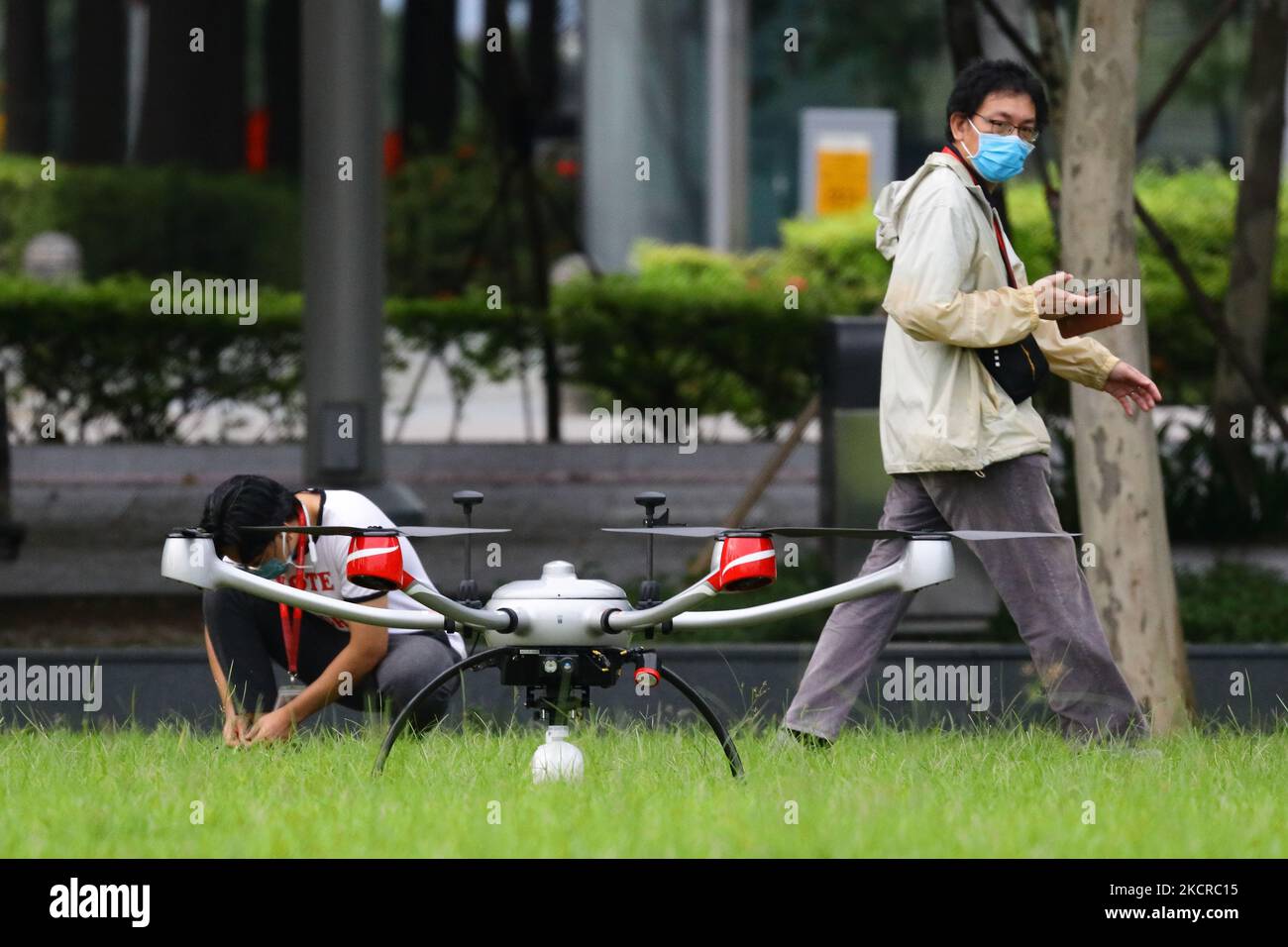 Zwei Männer mit Schutzmaske bereiten sich darauf vor, am 24. Oktober 2021 in Singapur eine Drohne in Marina Bay zu fliegen. (Foto von Suhaimi Abdullah/NurPhoto) Stockfoto