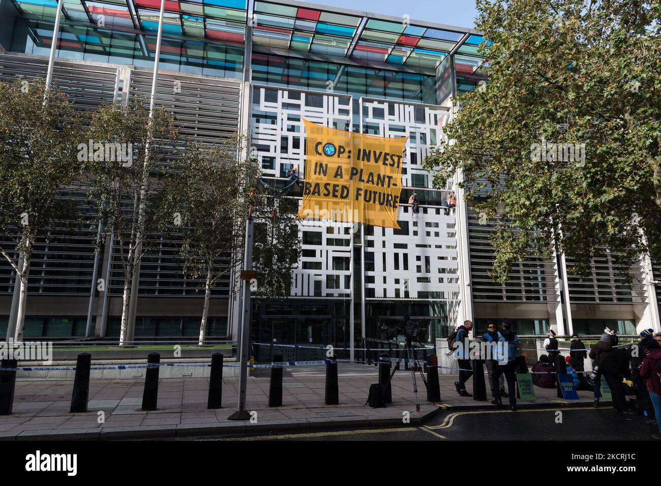 LONDON, GROSSBRITANNIEN – 26. OKTOBER 2021: Aktivisten von Animal Rebellion stiegen auf die Außenseite des Gebäudes des Department for Environment, Food and Rural Affairs (Defra) und ließen ein Banner fallen, das die britische Regierung aufforderte, im Vorfeld der UN-Klimakonferenz COP26 in Glasgow in den Übergang zu einem pflanzenbasierten Ernährungssystem zu investieren. Die am Sonntag, dem 26. Oktober 2021 in London, England beginnt. (Foto von Wiktor Szymanowicz/NurPhoto) Stockfoto