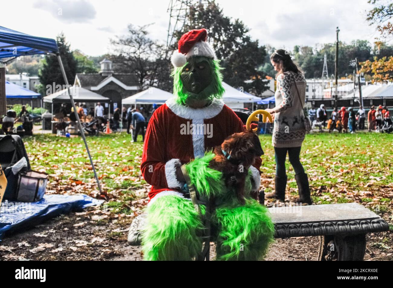 Der Grinch sitzt allein auf einer Bank im Park, der nach einem Weihnachten zum Verderben schlingt, sich aber während der frühen Trick or Treat-Aktivitäten in Philadelphia, PA, am 30. Oktober 2021 für einige Süßigkeiten einlässt. (Foto von Cory Clark/NurPhoto) Stockfoto