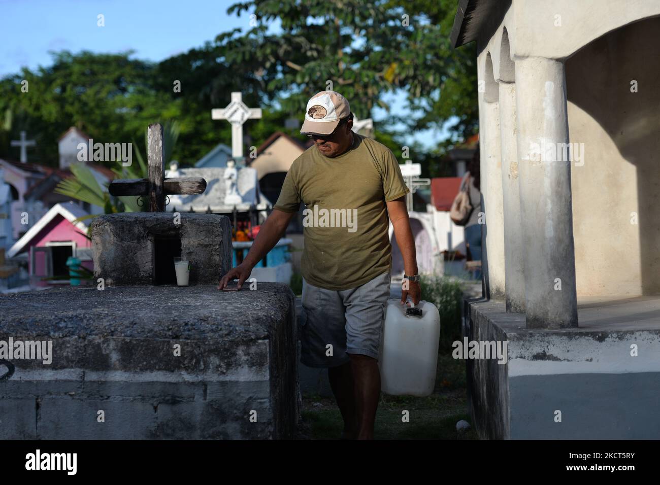 Ein Mann trägt ein Wasser auf dem städtischen Friedhof von Playa del Carmen. Der Allerheiligen-Tag in Mexiko fällt mit dem ersten Tag des Totenfestes (Día de Muertos) zusammen. Es erinnert an verstorbene Kinder (Dia de los Inocentes) und am zweiten Tag werden alle verstorbenen Erwachsenen gefeiert. 2008 wurde die Tradition von der UNESCO in die repräsentative Liste des immateriellen Kulturerbes der Menschheit aufgenommen. Am Dienstag, den 2. November 2021, in Playa Del Carmen, Quintana Roo, Mexiko. (Foto von Artur Widak/NurPhoto) Stockfoto