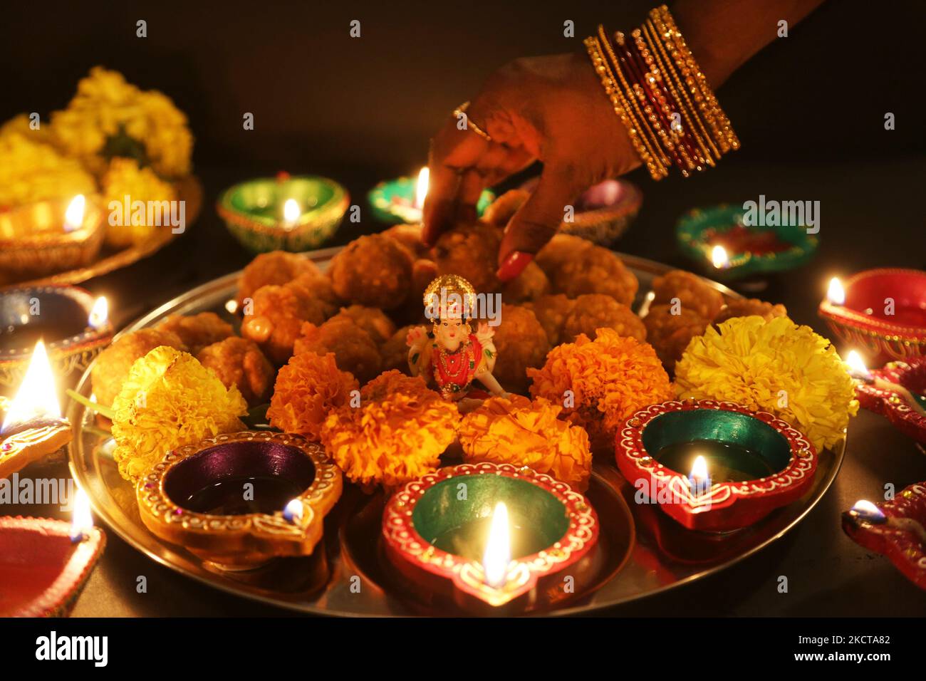 Diyas (kleine Tonlampen) umgeben ein Idol der Göttin Lakshmi (Göttin Laxmi) auf einem Tablett mit Ladoos (indischen Süßigkeiten) während des Festivals von Diwali in einem Hindu-Tempel in Toronto, Ontario, Kanada, am 04. November 2021. (Foto von Creative Touch Imaging Ltd./NurPhoto) Stockfoto Diyas (kleine Tonlampen) umgeben ein Idol der Göttin Lakshmi (Göttin Laxmi) auf einem Tablett mit Ladoos (indischen Süßigkeiten) während des Festivals von Diwali in einem Hindu-Tempel in Toronto, Ontario, Kanada, am 04. November 2021. (Foto von Creative Touch Imaging Ltd./NurPhoto) Stockfoto