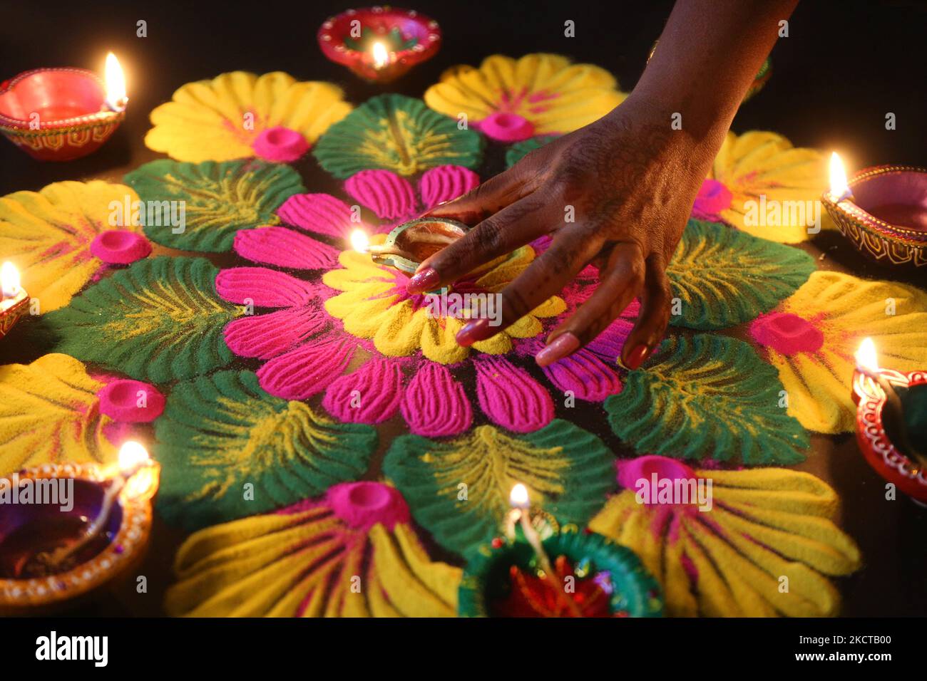 Hindu Woman setzt eine Diya (kleine Tonlampe) auf ein farbenfrohes Rangloli-Design, das am 04. November 2021 während des Festivals von Diwali in einem Hindu-Tempel in Toronto, Ontario, Kanada, mit farbigem Pulver entstand. Rangoli ist ein traditionelles Design, das auf dem Boden mit farbigem Pulver gezeichnet wurde, oft vor Häusern oder Tempeln. (Foto von Creative Touch Imaging Ltd./NurPhoto) Stockfoto Hindu Woman setzt eine Diya (kleine Tonlampe) auf ein farbenfrohes Rangloli-Design, das am 04. November 2021 während des Festivals von Diwali in einem Hindu-Tempel in Toronto, Ontario, Kanada, mit farbigem Pulver entstand. Rangoli ist ein traditionelles Design, das auf dem Boden mit farbigem Pulver gezeichnet wurde, oft vor Häusern oder Tempeln. (Foto von Creative Touch Imaging Ltd./NurPhoto) Stockfoto