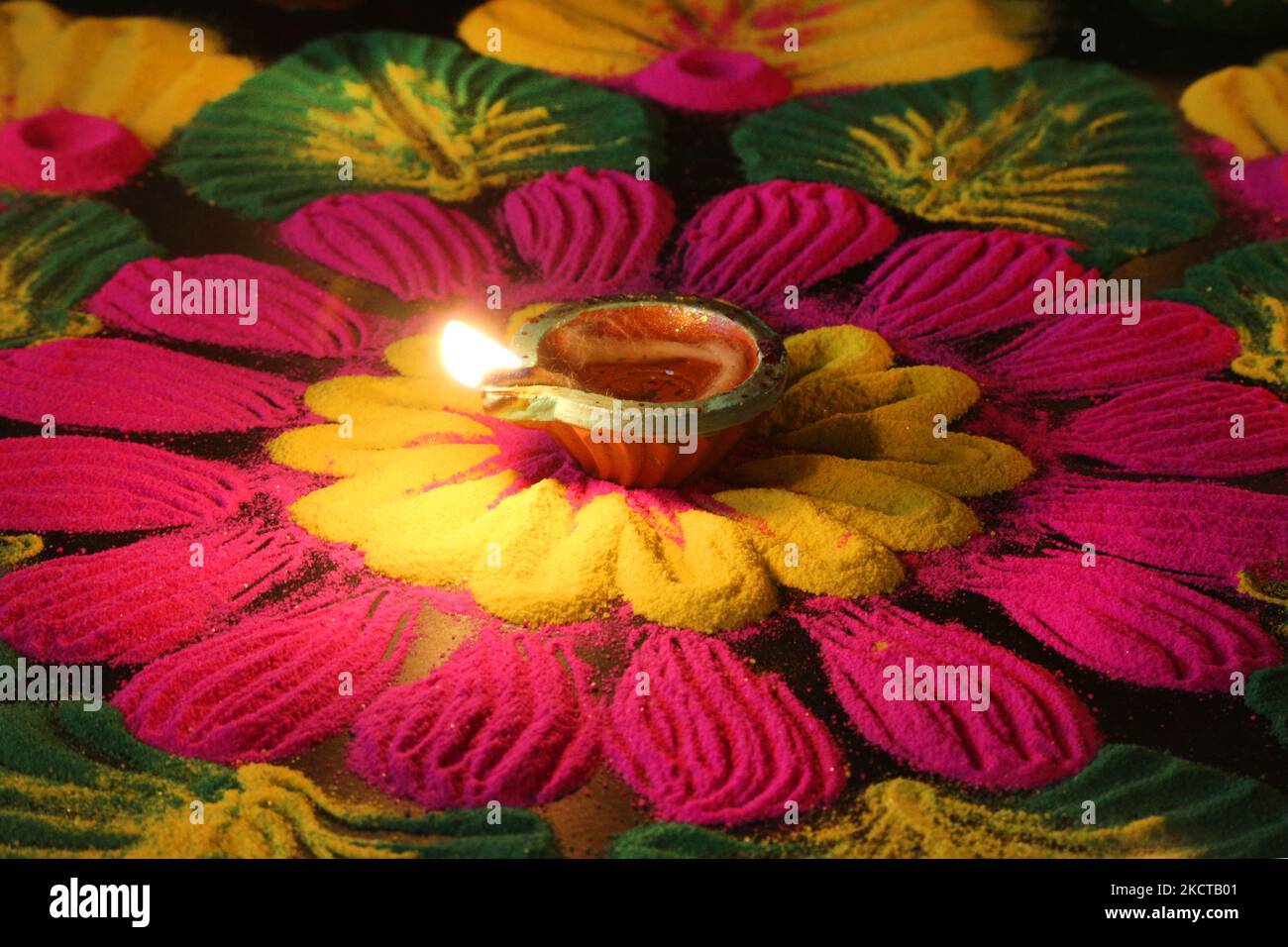 Diya (kleine Tonlampe) nach einem farbenfrohen Rangloli-Design, das mit farbigem Pulver während des Festivals von Diwali in einem Hindu-Tempel in Toronto, Ontario, Kanada, am 04. November 2021 geschaffen wurde. Rangoli ist ein traditionelles Design, das auf dem Boden mit farbigem Pulver gezeichnet wurde, oft vor Häusern oder Tempeln. (Foto von Creative Touch Imaging Ltd./NurPhoto) Stockfoto Diya (kleine Tonlampe) nach einem farbenfrohen Rangloli-Design, das mit farbigem Pulver während des Festivals von Diwali in einem Hindu-Tempel in Toronto, Ontario, Kanada, am 04. November 2021 geschaffen wurde. Rangoli ist ein traditionelles Design, das auf dem Boden mit farbigem Pulver gezeichnet wurde, oft vor Häusern oder Tempeln. (Foto von Creative Touch Imaging Ltd./NurPhoto) Stockfoto