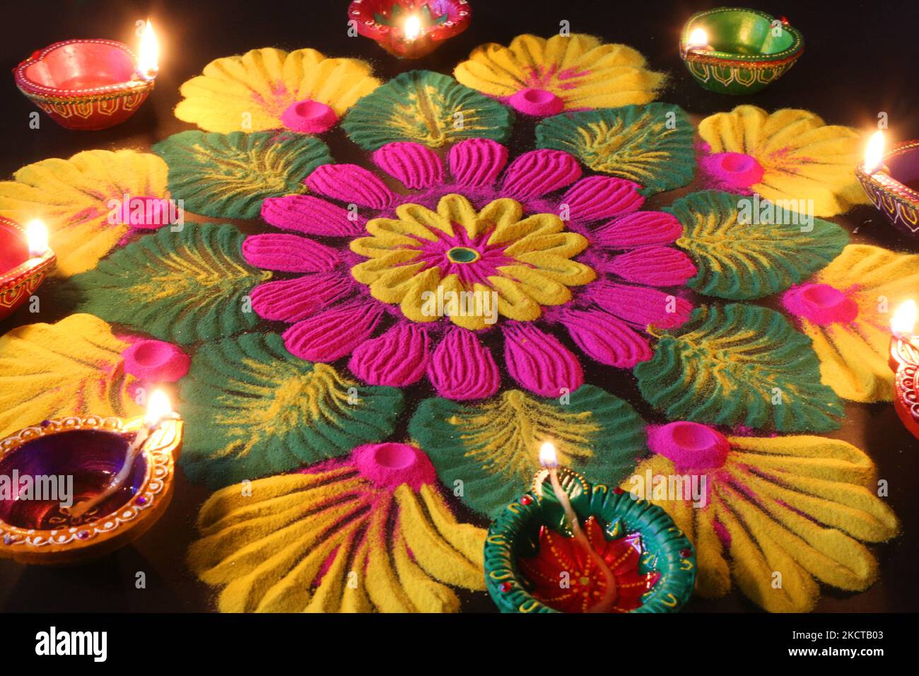 Diyas (kleine Tonlampen) nach einem farbenfrohen Rangloli-Design, das mit farbigem Pulver während des Festivals von Diwali in einem Hindu-Tempel in Toronto, Ontario, Kanada, am 04. November 2021 geschaffen wurde. Rangoli ist ein traditionelles Design, das auf dem Boden mit farbigem Pulver gezeichnet wurde, oft vor Häusern oder Tempeln. (Foto von Creative Touch Imaging Ltd./NurPhoto) Stockfoto