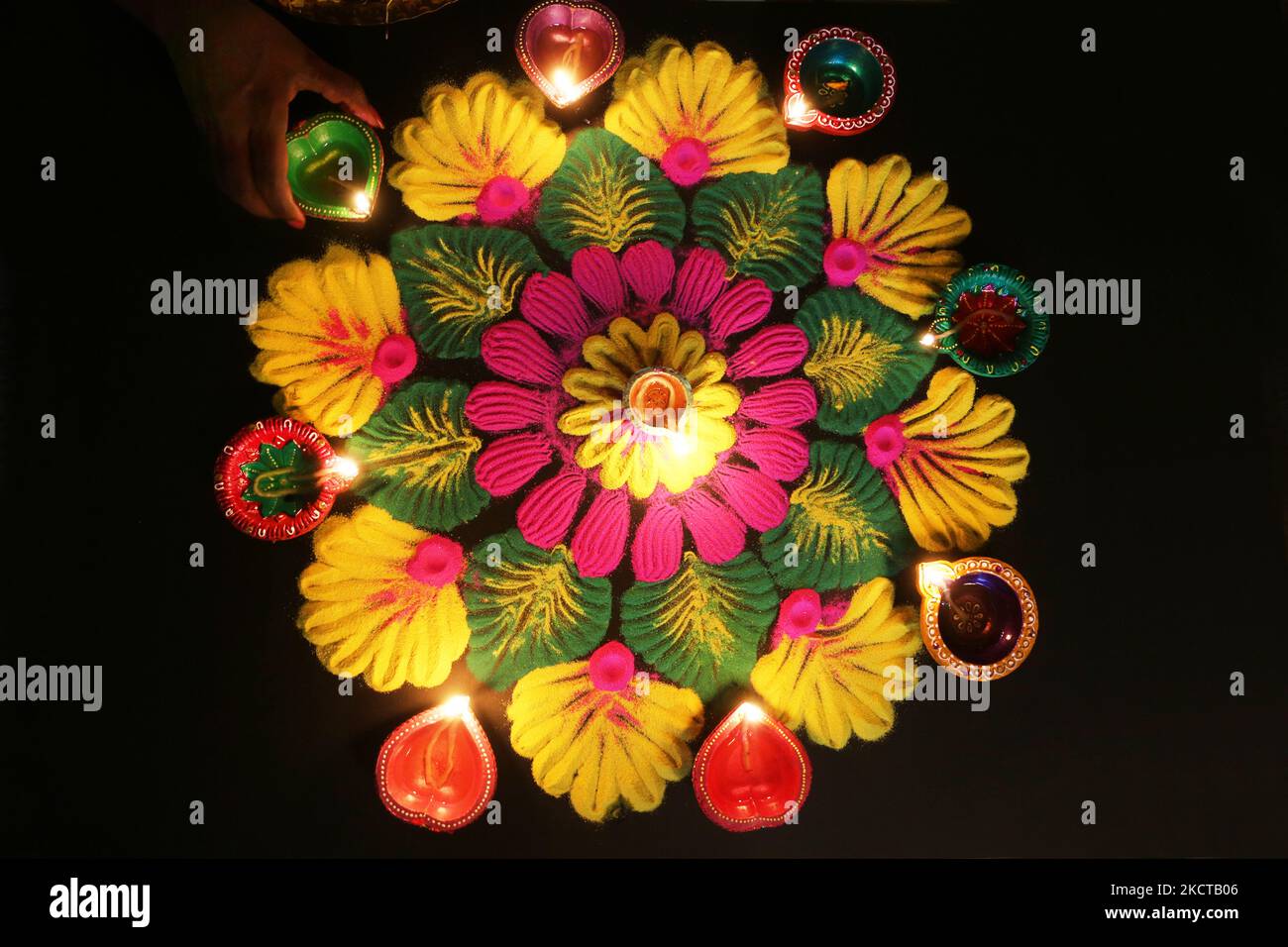 Hindu Woman setzt eine Diya (kleine Tonlampe) auf ein farbenfrohes Rangloli-Design, das am 04. November 2021 während des Festivals von Diwali in einem Hindu-Tempel in Toronto, Ontario, Kanada, mit farbigem Pulver entstand. Rangoli ist ein traditionelles Design, das auf dem Boden mit farbigem Pulver gezeichnet wurde, oft vor Häusern oder Tempeln. (Foto von Creative Touch Imaging Ltd./NurPhoto) Stockfoto Hindu Woman setzt eine Diya (kleine Tonlampe) auf ein farbenfrohes Rangloli-Design, das am 04. November 2021 während des Festivals von Diwali in einem Hindu-Tempel in Toronto, Ontario, Kanada, mit farbigem Pulver entstand. Rangoli ist ein traditionelles Design, das auf dem Boden mit farbigem Pulver gezeichnet wurde, oft vor Häusern oder Tempeln. (Foto von Creative Touch Imaging Ltd./NurPhoto) Stockfoto