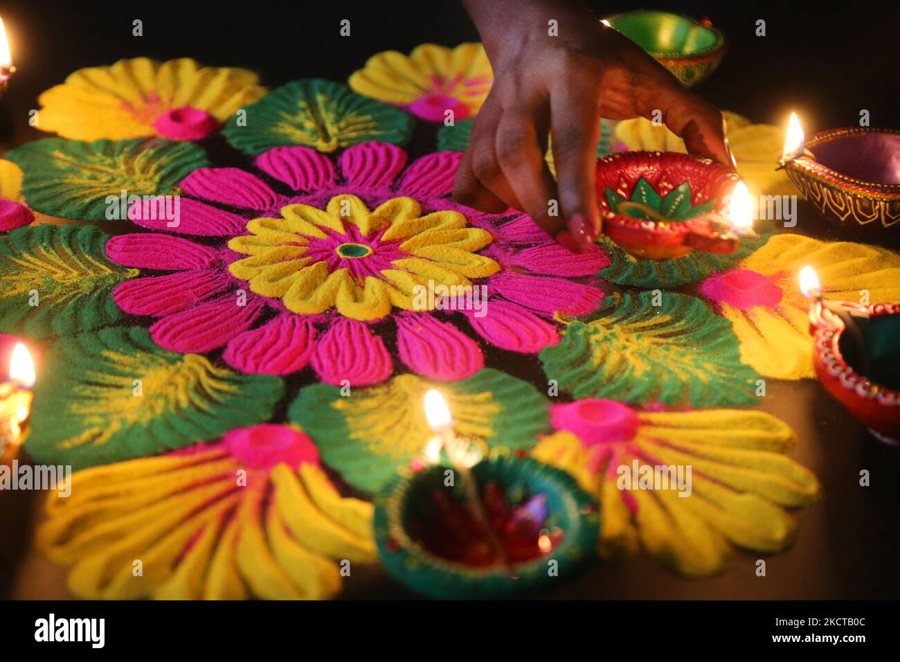 Hindu Woman setzt eine Diya (kleine Tonlampe) auf ein farbenfrohes Rangloli-Design, das am 04. November 2021 während des Festivals von Diwali in einem Hindu-Tempel in Toronto, Ontario, Kanada, mit farbigem Pulver entstand. Rangoli ist ein traditionelles Design, das auf dem Boden mit farbigem Pulver gezeichnet wurde, oft vor Häusern oder Tempeln. (Foto von Creative Touch Imaging Ltd./NurPhoto) Stockfoto Hindu Woman setzt eine Diya (kleine Tonlampe) auf ein farbenfrohes Rangloli-Design, das am 04. November 2021 während des Festivals von Diwali in einem Hindu-Tempel in Toronto, Ontario, Kanada, mit farbigem Pulver entstand. Rangoli ist ein traditionelles Design, das auf dem Boden mit farbigem Pulver gezeichnet wurde, oft vor Häusern oder Tempeln. (Foto von Creative Touch Imaging Ltd./NurPhoto) Stockfoto
