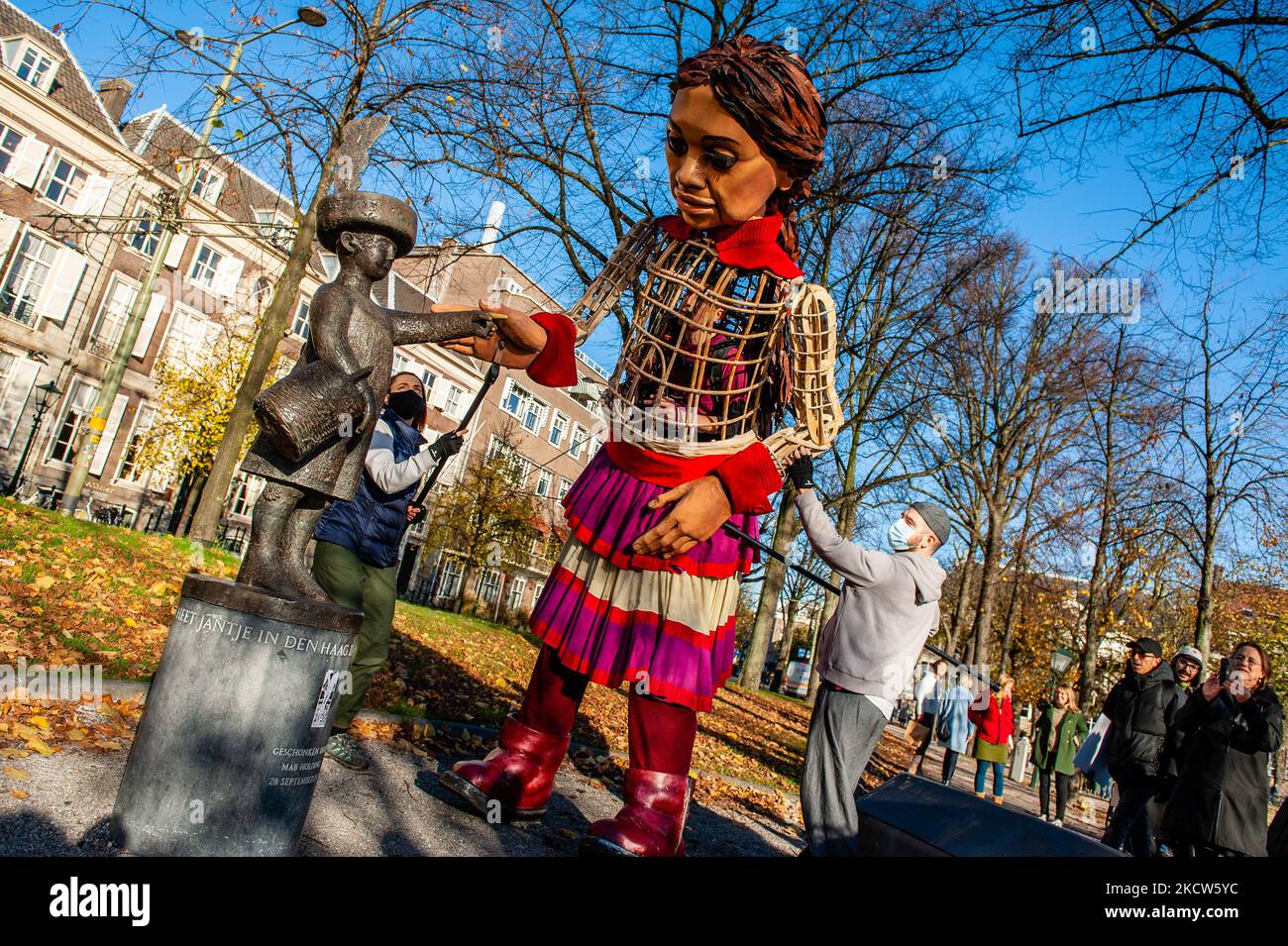 Die kleine Amal interagiert während ihres Besuchs in Den Haag mit einer der Skulpturen im Stadtzentrum, um am 19.. November 2021 in ganz Europa auf die Not junger Flüchtlinge aufmerksam zu machen, die aus Syrien geflohen sind. (Foto von Romy Arroyo Fernandez/NurPhoto) Stockfoto