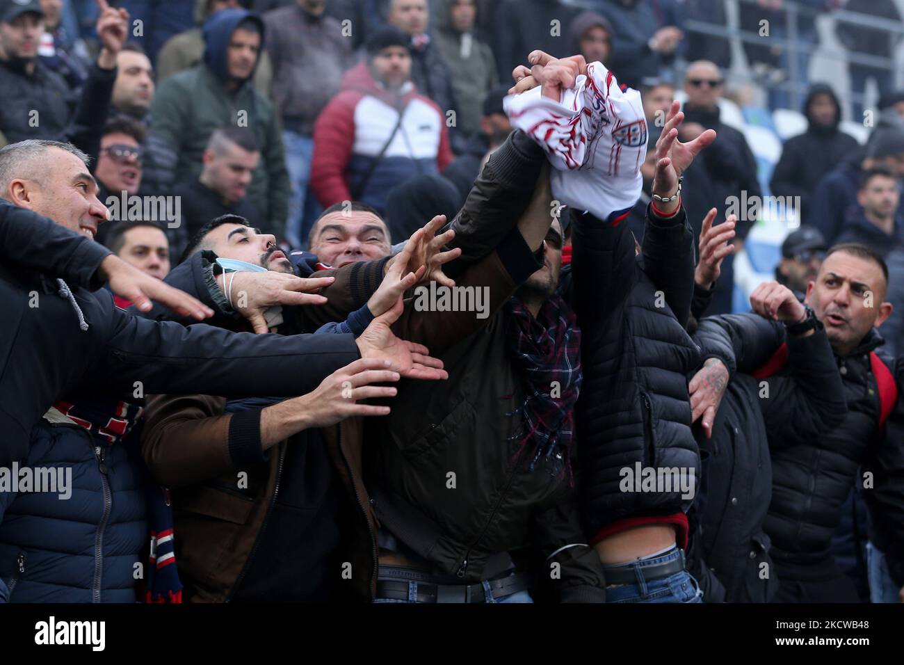 Cagliari-Fans kämpfen während des spiels der italienischen Fußballserie A US Sassuolo gegen Cagliari Calcio am 21. November 2021 im MAPEI-Stadion in Reggio Emilia, Italien, um ein Spielertrikot (Foto: Francesco Scaccianoce/LiveMedia/NurPhoto) Stockfoto