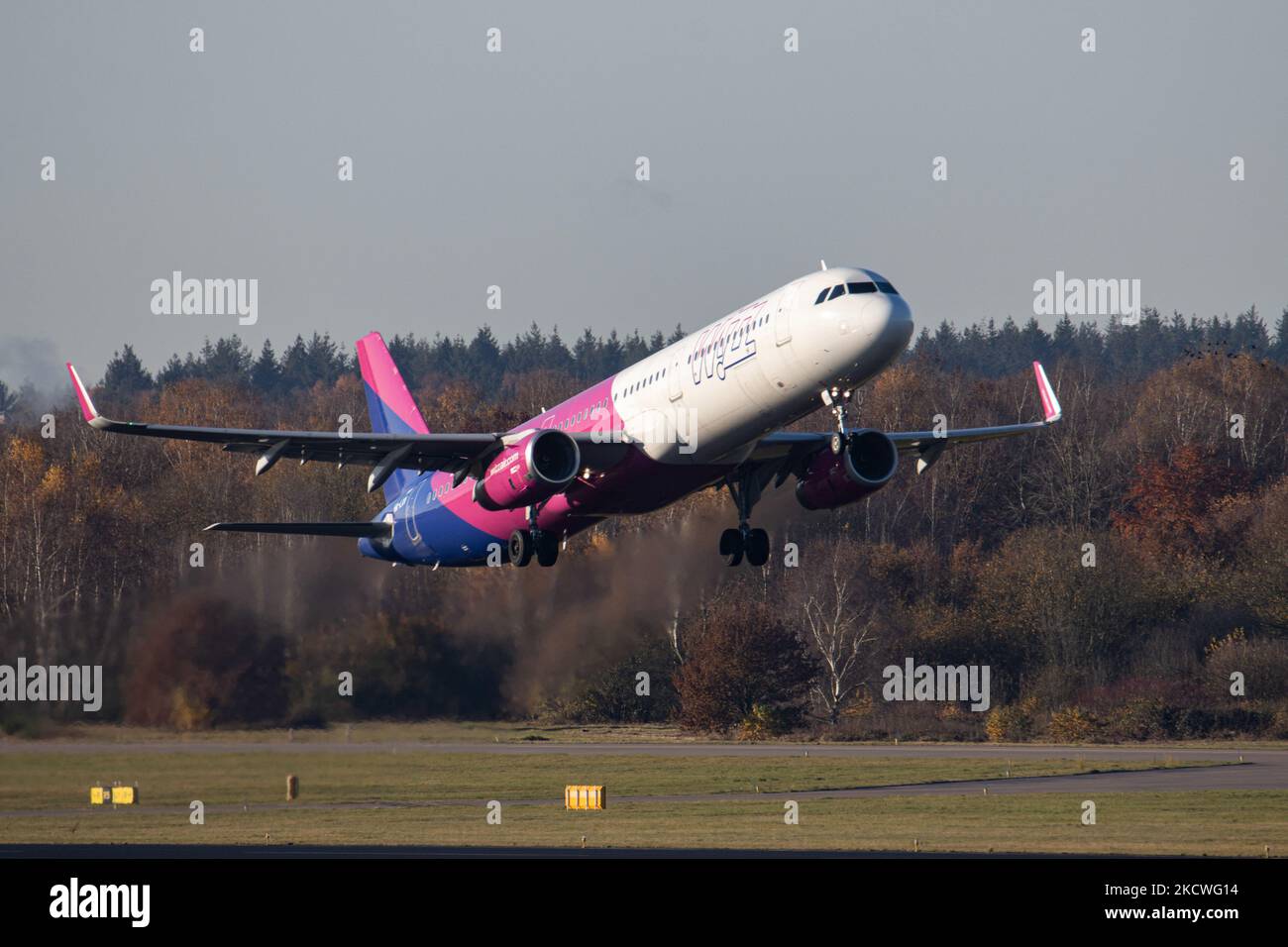 Wizz Air Airbus A321-Flugzeuge, wie sie während des Rollens, des Start- und der Flugphase vom Flughafen Eindhoven WÄHREND eines sonnigen Wintertages am blauen Himmel gesehen werden. W!ZZ Air ist ein ungarischer Ultra Low Cost Airline Carrier mit den größten Stützpunkten am Flughafen Budapest und am Flughafen Luton, der 164 Flughäfen anfliegt. Das Flugzeug A321-200 mit der Logo-Aufschrift auf der Seite hat die Registrierung HA-LXV. Die weltweite Luftfahrtindustrie versucht, sich von den negativen Auswirkungen der Coronavirus-Pandemie Covid-19 zu erholen. Eindhoven, Niederlande am 22. November 2021 (Foto: Nicolas Economou/NurPhoto) Stockfoto