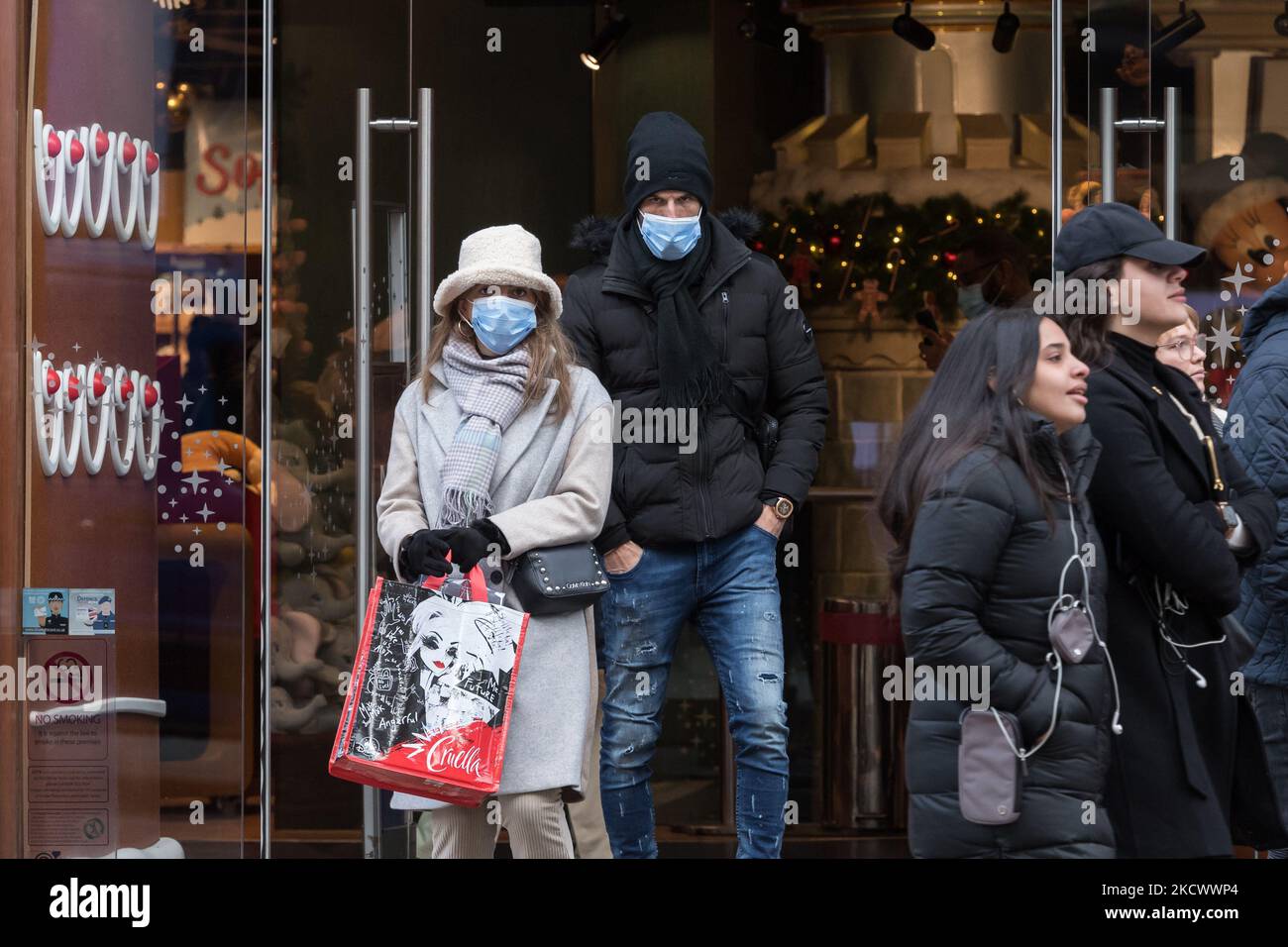 LONDON, VEREINIGTES KÖNIGREICH - 29. NOVEMBER 2021: Käufer mit Gesichtsmasken verlassen den Disney-Laden in der Oxford Street, bevor Maßnahmen zur Verlangsamung der Ausbreitung der neuen Variante des Coronavirus, Omicron, eingeführt werden, die am 29. November 2021 in London, England, eher übertragbar zu sein scheint. Ab morgen werden Gesichtsbedeckungen in Geschäften und öffentlichen Verkehrsmitteln in England verpflichtend, PCR-Tests werden bei Einreisen in das Vereinigte Königreich wieder eingeführt, und Kontakte von Verdachtsfällen müssen sich unabhängig vom Impfstatus selbst isolieren. (Foto von Wiktor Szymanowicz/NurPhoto) Stockfoto