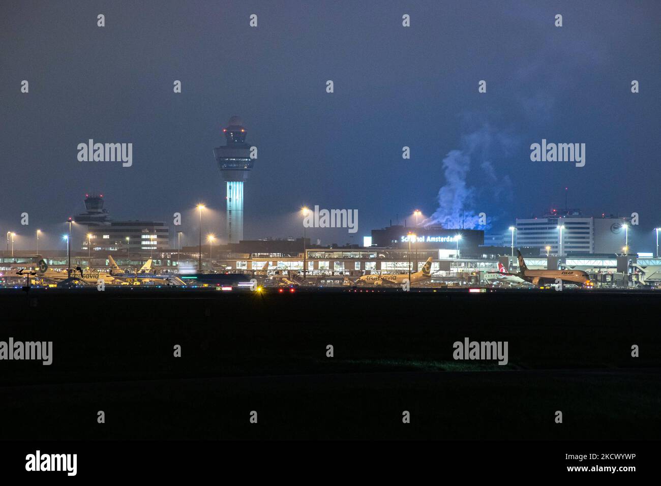 Nachtansicht des Flughafens Amsterdam Schiphol AMS mit Flugzeugen vor den Toren. 14 Fälle der neuen COVID-19-Variante Omicron wurden in den Niederlanden von Passagieren bestätigt, die aus Südafrika in die niederländische Stadt kamen. Mehr als 600 Passagiere wurden von den 2 Flügen getestet, wobei 61 positiv für Covid-19 bestätigt wurden. Die niederländische Polizei verhaftete zuvor zwei Passagiere, die sich in einem Quarantänehotel aufgehalten haben, als sie versuchten zu entkommen. Viele Länder haben Flüge nach Südafrika während einer bereits schwierigen Zeit mit der Coronavirus-Pandemie, die sich negativ auf die Luftfahrtindustrie auswirkte, eingestellt. Stockfoto