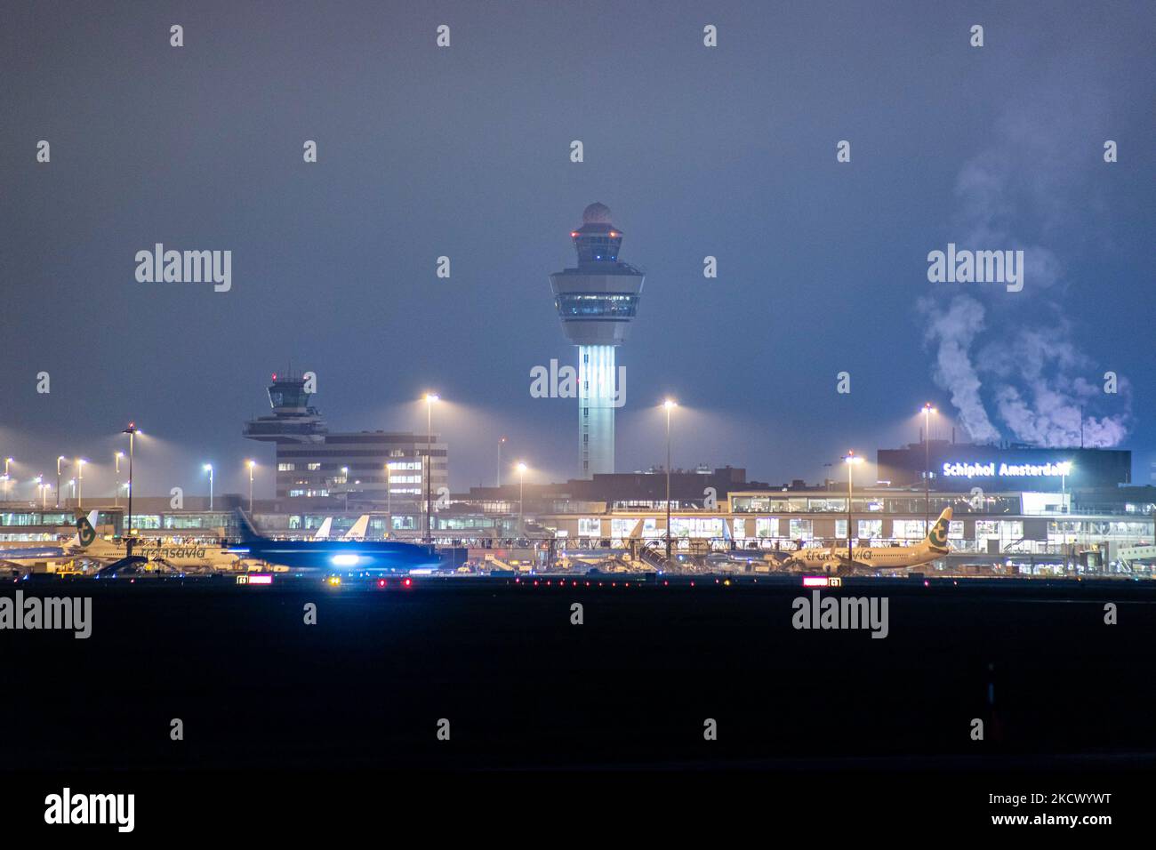 Nachtansicht des Flughafens Amsterdam Schiphol AMS mit Flugzeugen vor den Toren. 14 Fälle der neuen COVID-19-Variante Omicron wurden in den Niederlanden von Passagieren bestätigt, die aus Südafrika in die niederländische Stadt kamen. Mehr als 600 Passagiere wurden von den 2 Flügen getestet, wobei 61 positiv für Covid-19 bestätigt wurden. Die niederländische Polizei verhaftete zuvor zwei Passagiere, die sich in einem Quarantänehotel aufgehalten haben, als sie versuchten zu entkommen. Viele Länder haben Flüge nach Südafrika während einer bereits schwierigen Zeit mit der Coronavirus-Pandemie, die sich negativ auf die Luftfahrtindustrie auswirkte, eingestellt. Stockfoto