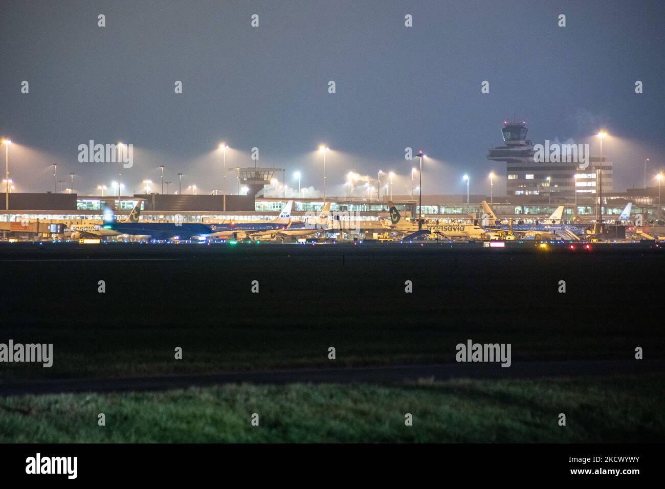 Nachtansicht des Flughafens Amsterdam Schiphol AMS mit Flugzeugen vor den Toren. 14 Fälle der neuen COVID-19-Variante Omicron wurden in den Niederlanden von Passagieren bestätigt, die aus Südafrika in die niederländische Stadt kamen. Mehr als 600 Passagiere wurden von den 2 Flügen getestet, wobei 61 positiv für Covid-19 bestätigt wurden. Die niederländische Polizei verhaftete zuvor zwei Passagiere, die sich in einem Quarantänehotel aufgehalten haben, als sie versuchten zu entkommen. Viele Länder haben Flüge nach Südafrika während einer bereits schwierigen Zeit mit der Coronavirus-Pandemie, die sich negativ auf die Luftfahrtindustrie auswirkte, eingestellt. Stockfoto