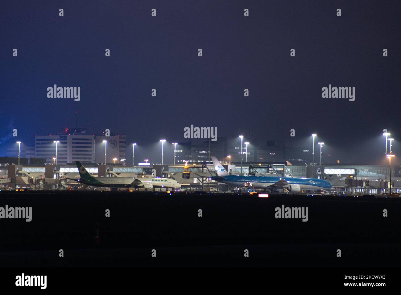 Nachtansicht des Flughafens Amsterdam Schiphol AMS mit Flugzeugen vor den Toren. 14 Fälle der neuen COVID-19-Variante Omicron wurden in den Niederlanden von Passagieren bestätigt, die aus Südafrika in die niederländische Stadt kamen. Mehr als 600 Passagiere wurden von den 2 Flügen getestet, wobei 61 positiv für Covid-19 bestätigt wurden. Die niederländische Polizei verhaftete zuvor zwei Passagiere, die sich in einem Quarantänehotel aufgehalten haben, als sie versuchten zu entkommen. Viele Länder haben Flüge nach Südafrika während einer bereits schwierigen Zeit mit der Coronavirus-Pandemie, die sich negativ auf die Luftfahrtindustrie auswirkte, eingestellt. Stockfoto