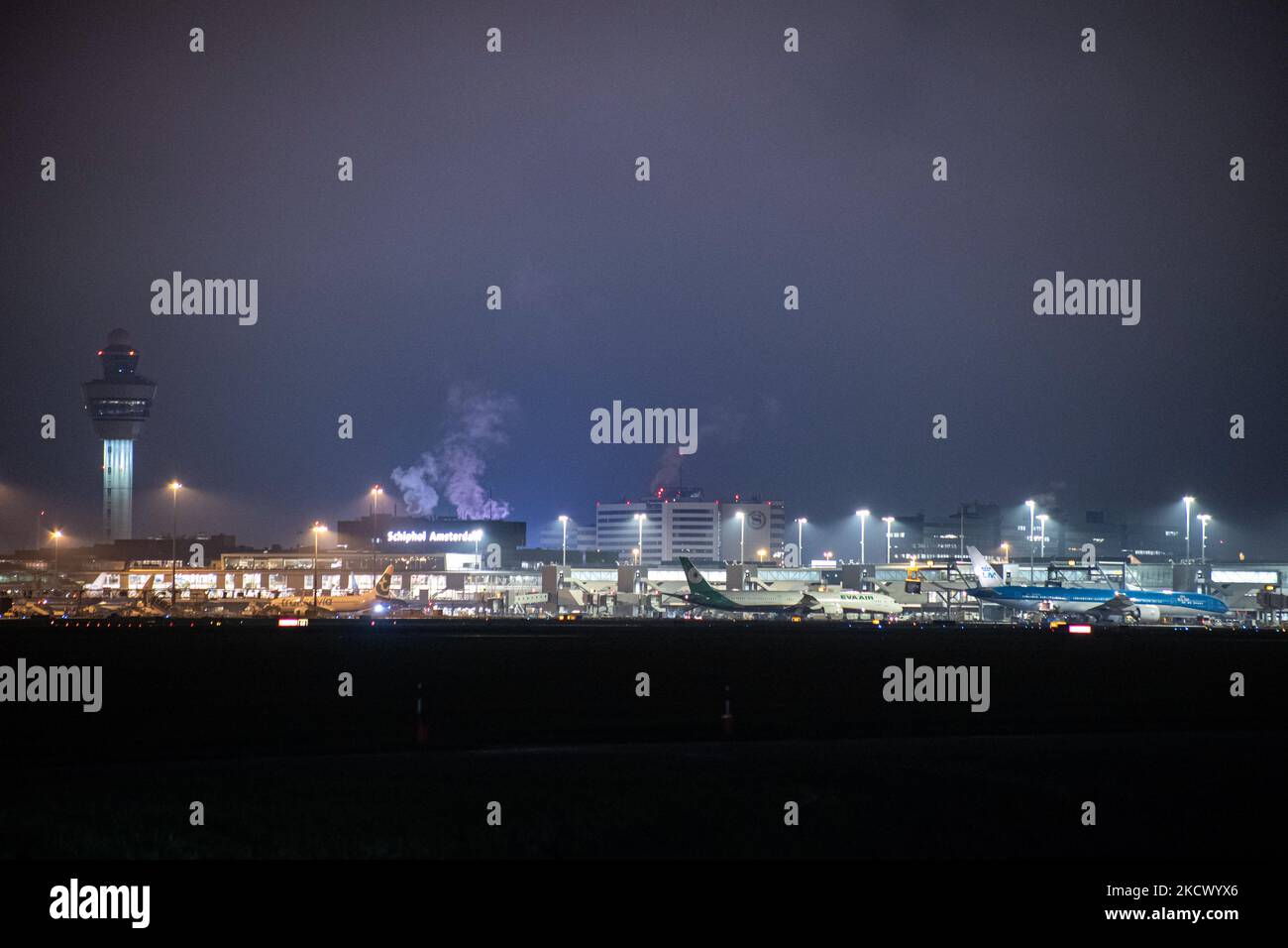 Nachtansicht des Flughafens Amsterdam Schiphol AMS mit Flugzeugen vor den Toren. 14 Fälle der neuen COVID-19-Variante Omicron wurden in den Niederlanden von Passagieren bestätigt, die aus Südafrika in die niederländische Stadt kamen. Mehr als 600 Passagiere wurden von den 2 Flügen getestet, wobei 61 positiv für Covid-19 bestätigt wurden. Die niederländische Polizei verhaftete zuvor zwei Passagiere, die sich in einem Quarantänehotel aufgehalten haben, als sie versuchten zu entkommen. Viele Länder haben Flüge nach Südafrika während einer bereits schwierigen Zeit mit der Coronavirus-Pandemie, die sich negativ auf die Luftfahrtindustrie auswirkte, eingestellt. Stockfoto