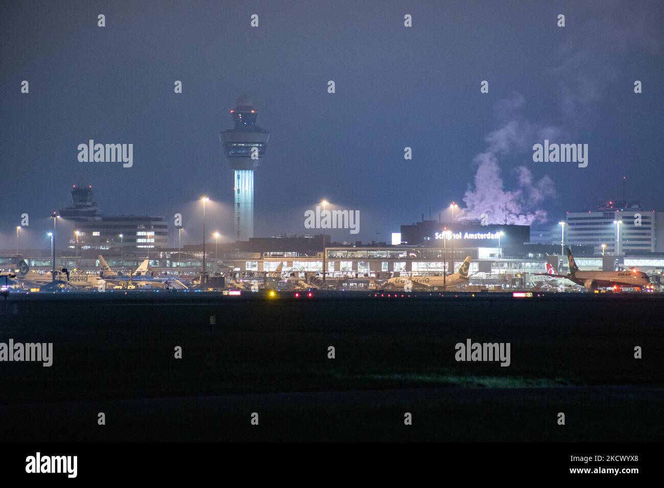 Nachtansicht des Flughafens Amsterdam Schiphol AMS mit Flugzeugen vor den Toren. 14 Fälle der neuen COVID-19-Variante Omicron wurden in den Niederlanden von Passagieren bestätigt, die aus Südafrika in die niederländische Stadt kamen. Mehr als 600 Passagiere wurden von den 2 Flügen getestet, wobei 61 positiv für Covid-19 bestätigt wurden. Die niederländische Polizei verhaftete zuvor zwei Passagiere, die sich in einem Quarantänehotel aufgehalten haben, als sie versuchten zu entkommen. Viele Länder haben Flüge nach Südafrika während einer bereits schwierigen Zeit mit der Coronavirus-Pandemie, die sich negativ auf die Luftfahrtindustrie auswirkte, eingestellt. Stockfoto