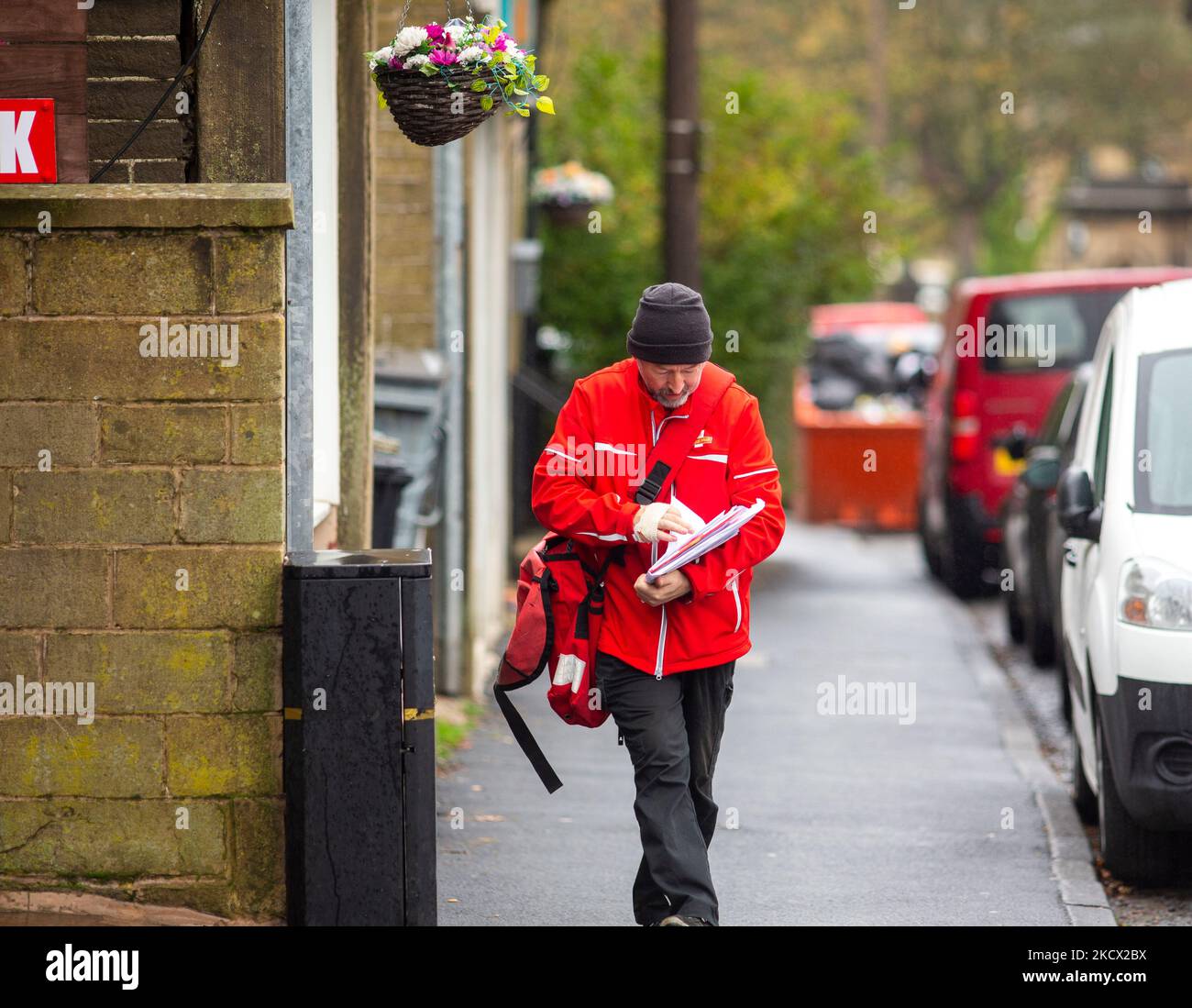 Ein Postarbeiter in Queensbury, West Yorkshire. Royal Mail Workers wird zwei 48-stündige Streiks um den Black Friday und den Cyber Monday in Folge über Bezahlung, Arbeitsplätze und Bedingungen führen. Die Gewerkschaft der Kommunikationsarbeiter (CWU) wird rund 115.000 ihrer Mitglieder empfehlen, ein über zwei Jahre ausgebreites Lohnangebot von rund 9 % abzulehnen. Doch die Gewerkschaft hat am 12. Und 14. November zwei Streiks abgesagt und gesagt, sie wolle "verhältnismäßere" Maßnahmen ergreifen. Royal Mail forderte die Beschäftigten auf, in der „verkehrsreichsten Zeit des Jahres“ nicht zu streiken. Stockfoto