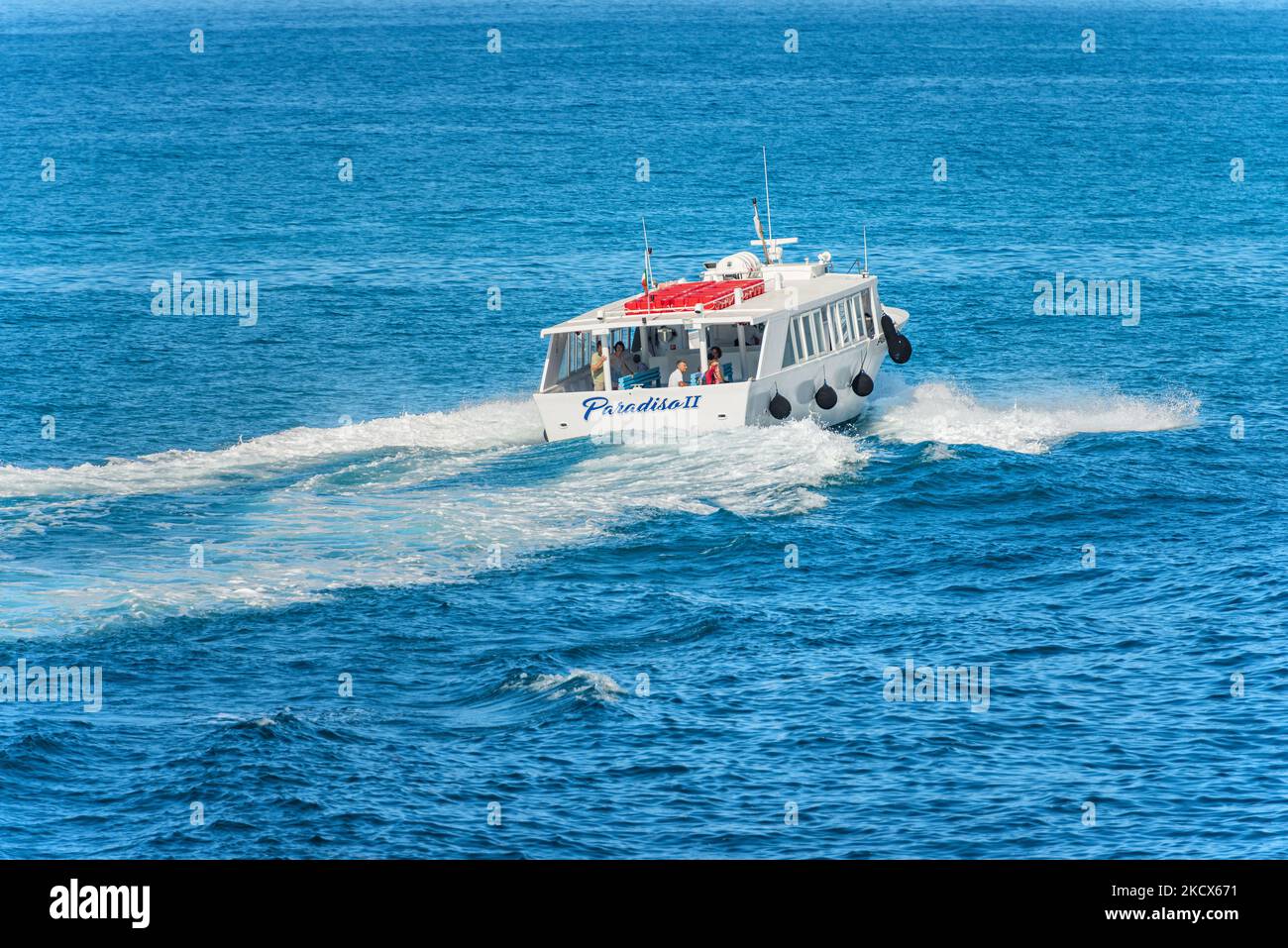 Schnelle Fähre mit einigen Touristen an Bord, in Bewegung im blauen Mittelmeer an einem sonnigen Sommertag, Rückansicht, Golf von La Spezia, Ligurien, Italien. Stockfoto