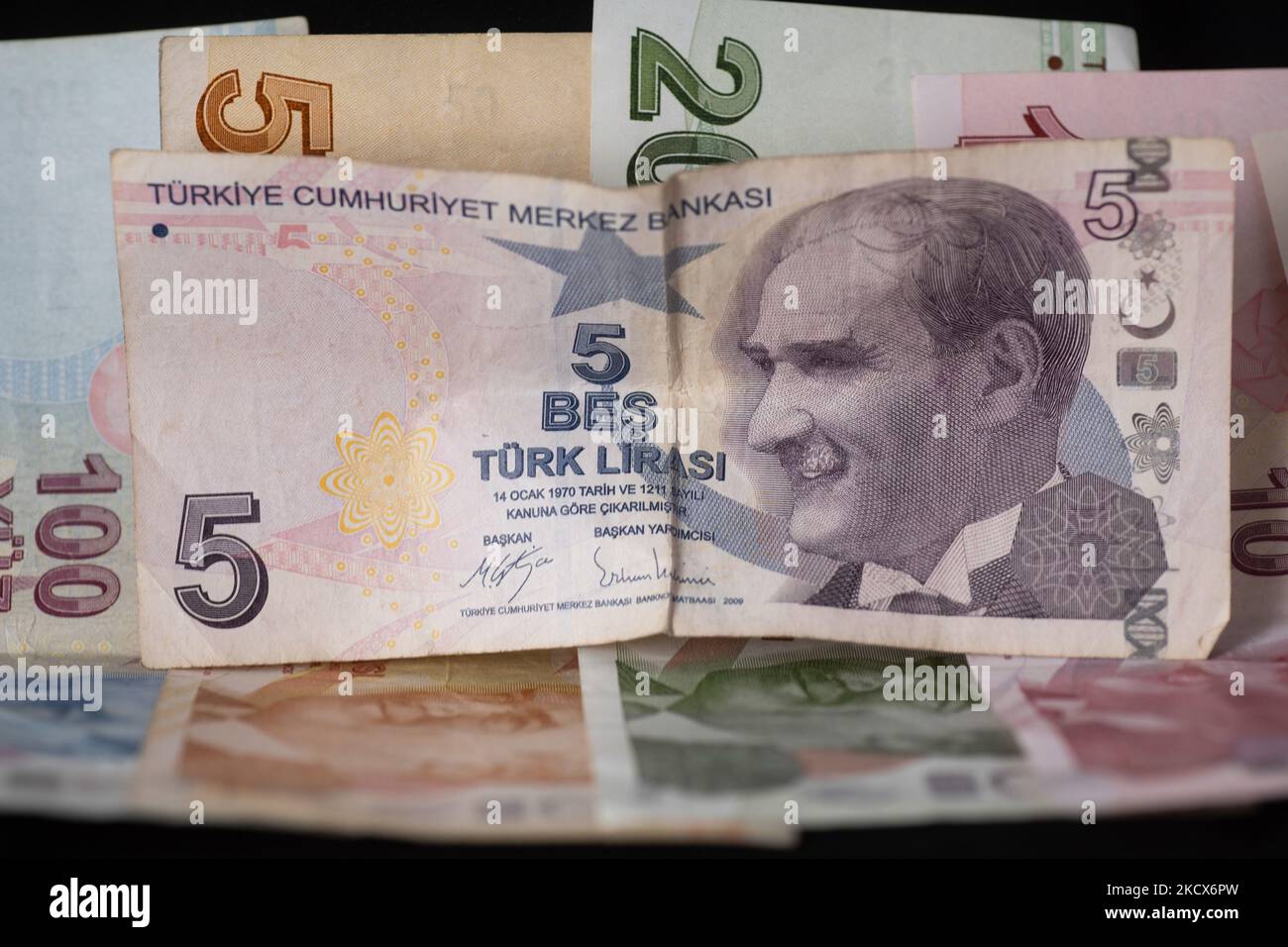 Foto Illustration von türkischen Lira-Banknoten auf schwarzem Hintergrund und einem Maßband als Symbol für die schrumpfende Wirtschaft und Währung. Die Lira erreicht ein neues Rekordtief, da die Währung die Verluste für den Handel über 13,73 pro US-Dollar und 15,51 Euro ausdehnte. Die türkische Lira rutscht auf ein Rekordtief, nachdem Präsident Erdogan die Leitzinspolitik verdoppelt hat. Illustration der türkischen Lira-Banknoten, die Währung der Türkei, in türkischer Sprache Türk Lira genannt, mit dem Zeichen: Und Code TRY oder TL. Auf der Vorderseite des Gesetzentwurfs sind Porträts von Mustafa Kemal Atatürk zu sehen. Amsterdam, Niederlande am 33. Dezember 2021. (Foto von Nicol Stockfoto