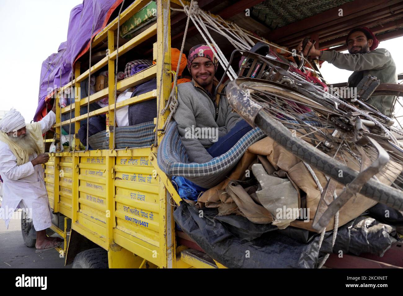Die Bauern steigen auf einem Lastwagen ein, während sie eine Proteststelle räumen, nachdem die Regierung am 12. Dezember 2021 in Ghazipur, am Stadtrand von Neu-Delhi, Indien, zugestimmt hatte, eine Reihe von Fragen zu akzeptieren, darunter die Versicherung des Mindeststützungspreises (MSP). (Foto von Mayank Makhija/NurPhoto) Stockfoto