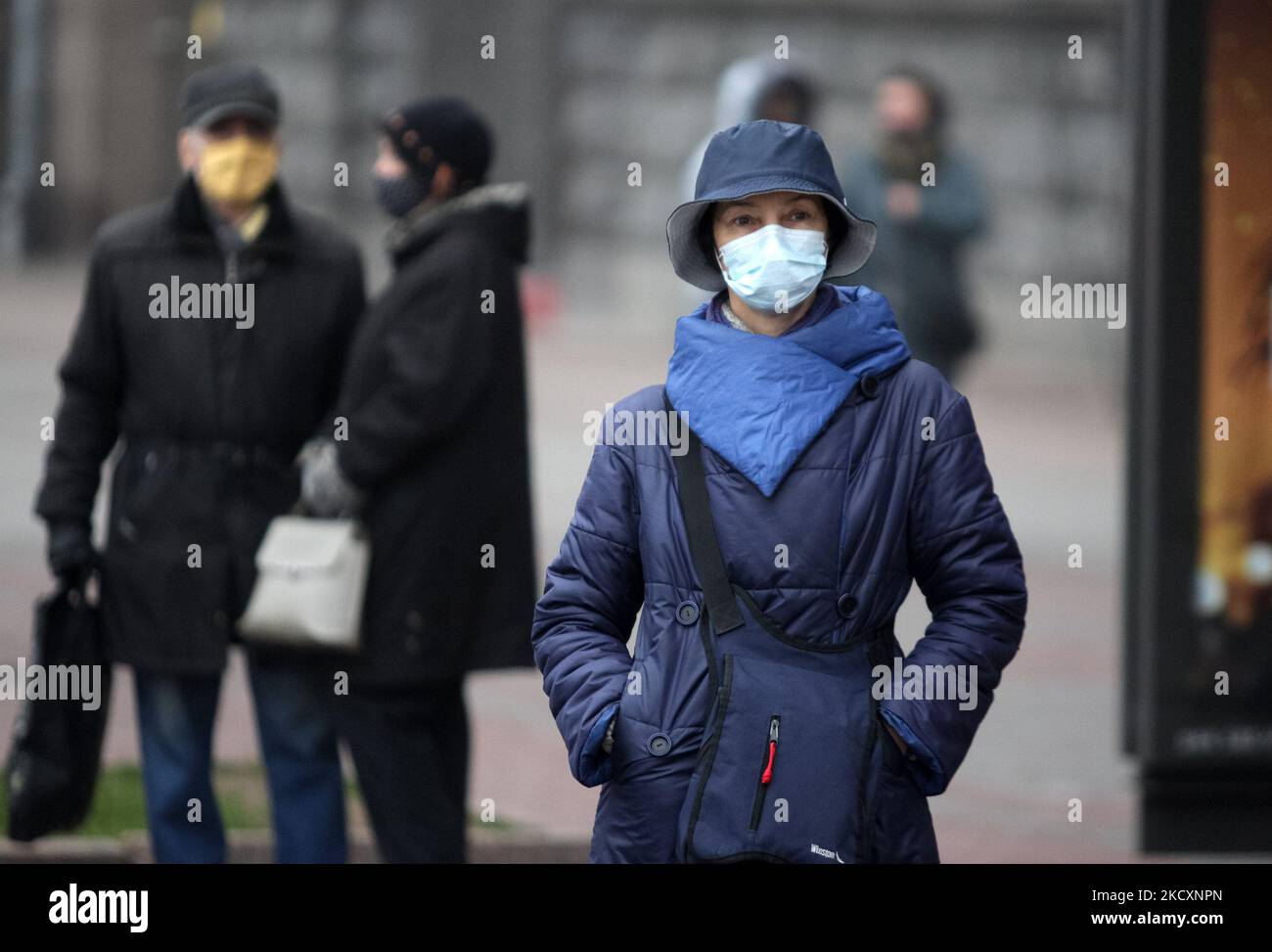 Menschen mit Gesichtsmasken als vorbeugende Maßnahme gegen das Coronavirus Covid-19 warten am 12. Dezember 2021 an der Haltestelle in der Innenstadt von Kiew, Ukraine, auf einen Bus. 91 027 Menschen sind im Land an dem Coronavirus Covid-19 gestorben. (Foto von STR/NurPhoto) Stockfoto