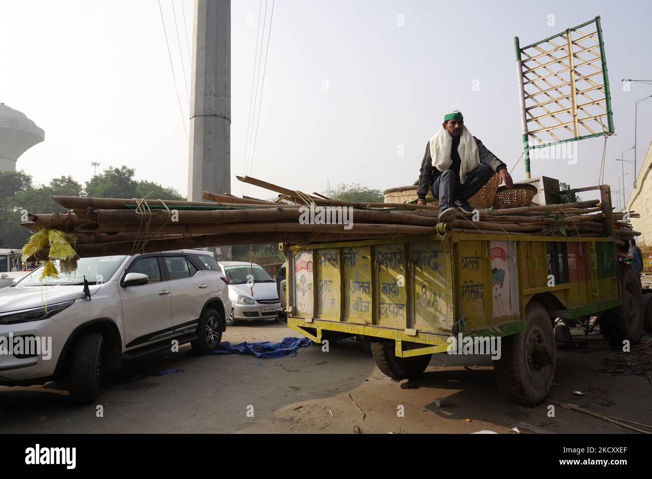 Ein Landwirt sitzt auf einem Traktorwagen, der mit seinen Habseligkeiten beladen ist, während er eine Proteststelle verlassen hat, nachdem die Regierung am 15. Dezember 2021 in Ghazipur an der Grenze zu Neu-Delhi, Indien, zugestimmt hatte, eine Reihe von Fragen zu akzeptieren, darunter die Versicherung des Mindeststützungspreises (MSP). (Foto von Mayank Makhija/NurPhoto) Stockfoto