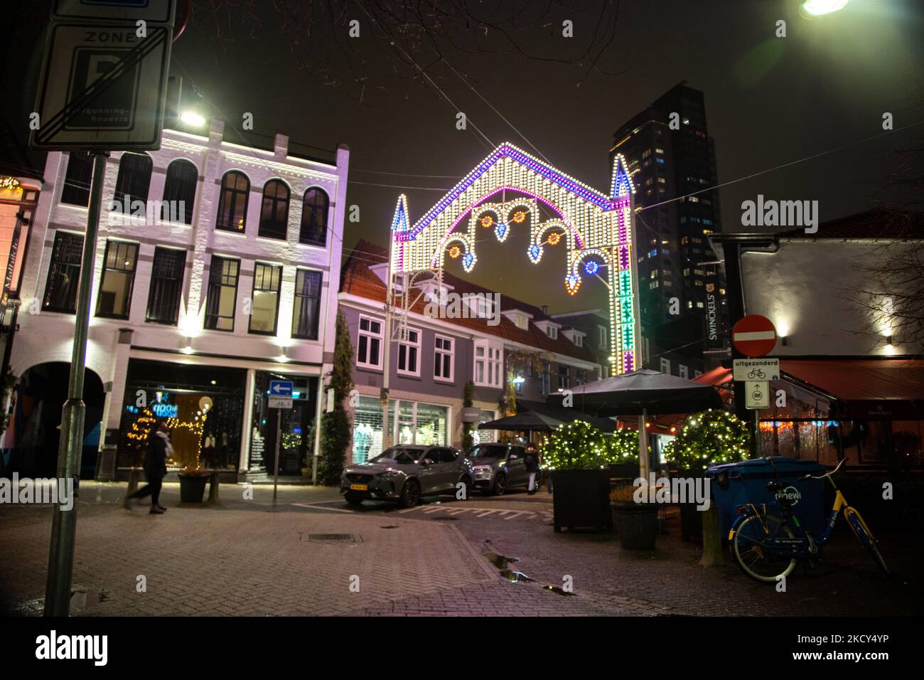 Nachtszene mit Weihnachtslichtern und ein paar Leuten im Zentrum von Eindhoven. Die erste europäische Nation erklärt eine vollständige Sperre, um gegen die neue Omicron-Variante zu kämpfen, die in die Höhe geht. Die Niederlande schließen, nachdem die Regierung die Schließung aller unwesentlichen Geschäfte, Cafés, Restaurants, Bars, Fitnessstudios, Schulen, Sportstätten, Kulturstätten und andere Orte ab Sonntag und für 4 Wochen, um die Ausbreitung der Omicron-Mutation des Covid-19-Coronavirus zu verhindern. Eindhoven, Niederlande am 18. Dezember 2021 (Foto von Nicolas Economou/NurPhoto) Stockfoto