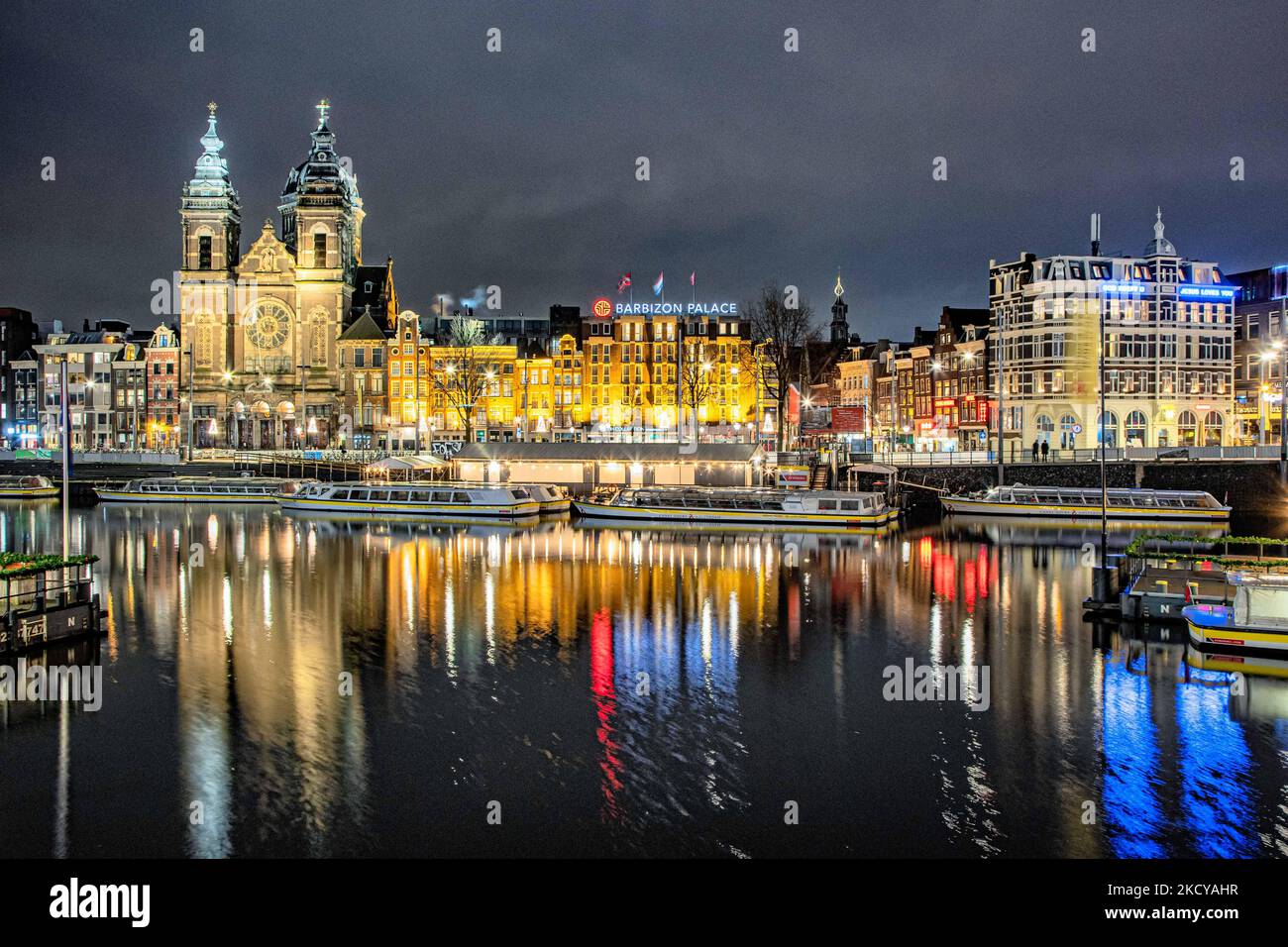 Nachtansicht der Kanäle mit Booten und Gebäuden mit ihrer Reflexion auf dem Wasser der Kanäle. Straßen von Amsterdam am ersten Tag der plötzlichen Sperrung in der niederländischen Hauptstadt. Die erste europäische Nation erklärt eine vollständige Sperre, um gegen die neue Omicron-Variante zu kämpfen, die in die Höhe geht. Die Niederlande schließen, nachdem die Regierung die Schließung aller unwesentlichen Geschäfte, Cafés, Restaurants, Bars, Fitnessstudios, Schulen, Sportstätten, Kulturstätten und andere Orte ab Sonntag und für 4 Wochen, um die Ausbreitung der Omicron-Mutation des Covid-19-Coronavirus zu verhindern. Amsterdam, Niederlande an Stockfoto