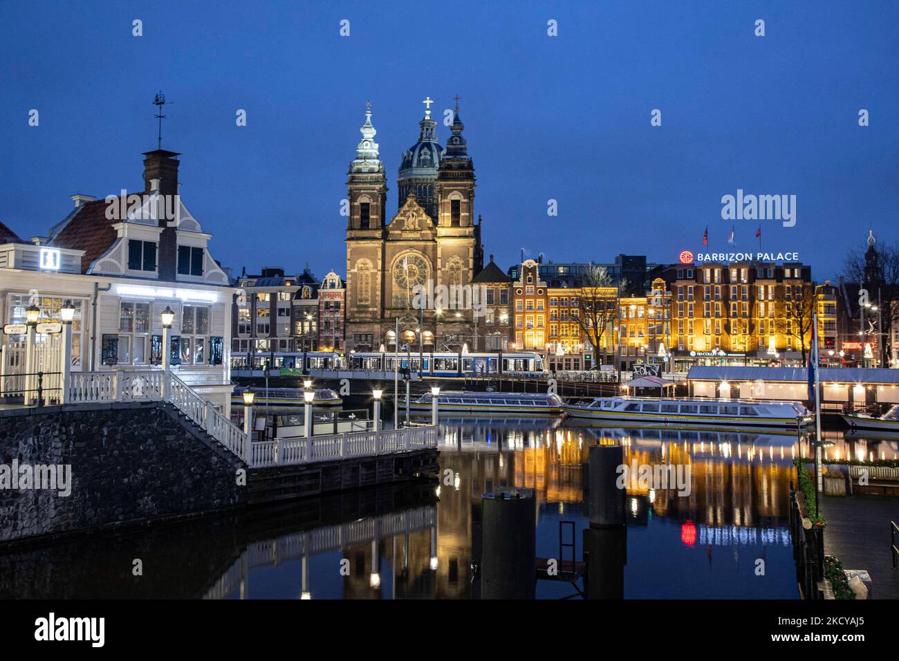 Nachtansicht der Kanäle mit Booten und Gebäuden mit ihrer Reflexion auf dem Wasser der Kanäle. Straßen von Amsterdam am ersten Tag der plötzlichen Sperrung in der niederländischen Hauptstadt. Die erste europäische Nation erklärt eine vollständige Sperre, um gegen die neue Omicron-Variante zu kämpfen, die in die Höhe geht. Die Niederlande schließen, nachdem die Regierung die Schließung aller unwesentlichen Geschäfte, Cafés, Restaurants, Bars, Fitnessstudios, Schulen, Sportstätten, Kulturstätten und andere Orte ab Sonntag und für 4 Wochen, um die Ausbreitung der Omicron-Mutation des Covid-19-Coronavirus zu verhindern. Amsterdam, Niederlande an Stockfoto