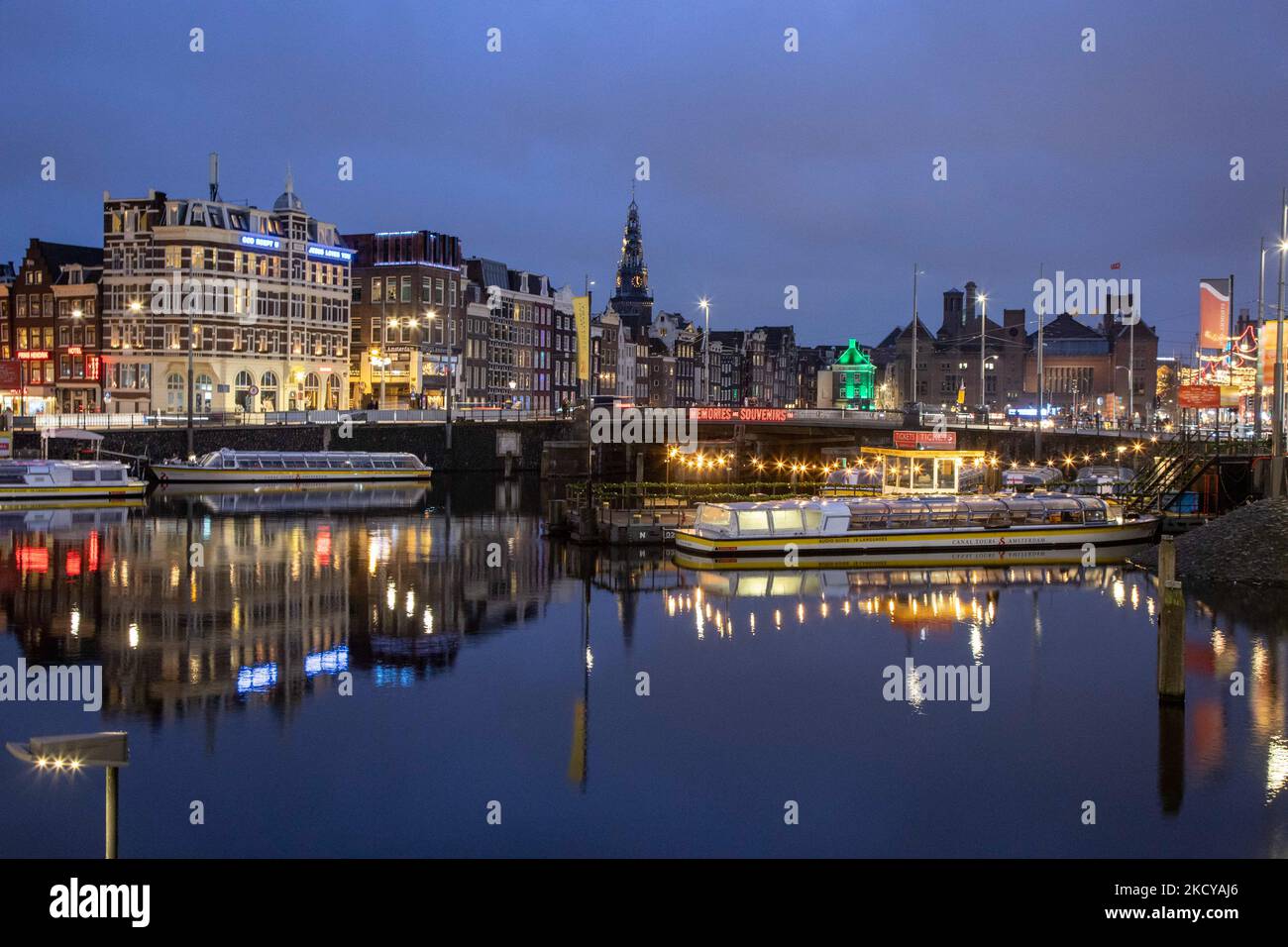 Nachtansicht der Kanäle mit Booten und Gebäuden mit ihrer Reflexion auf dem Wasser der Kanäle. Straßen von Amsterdam am ersten Tag der plötzlichen Sperrung in der niederländischen Hauptstadt. Die erste europäische Nation erklärt eine vollständige Sperre, um gegen die neue Omicron-Variante zu kämpfen, die in die Höhe geht. Die Niederlande schließen, nachdem die Regierung die Schließung aller unwesentlichen Geschäfte, Cafés, Restaurants, Bars, Fitnessstudios, Schulen, Sportstätten, Kulturstätten und andere Orte ab Sonntag und für 4 Wochen, um die Ausbreitung der Omicron-Mutation des Covid-19-Coronavirus zu verhindern. Amsterdam, Niederlande an Stockfoto