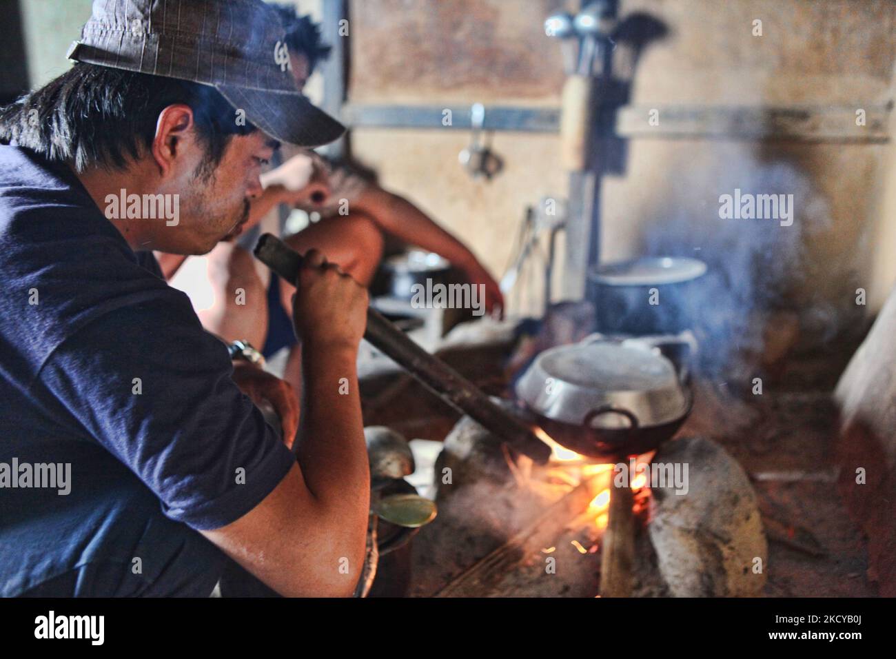 Lepcha Mann verwendet ein Bambusrohr, um die Glut in einem traditionellen chula (Erdofen) zu blasen, um das Feuer zum Kochen in einem kleinen Dorfhaus in Sikkim, Indien, zu entzünden. (Foto von Creative Touch Imaging Ltd./NurPhoto) Stockfoto