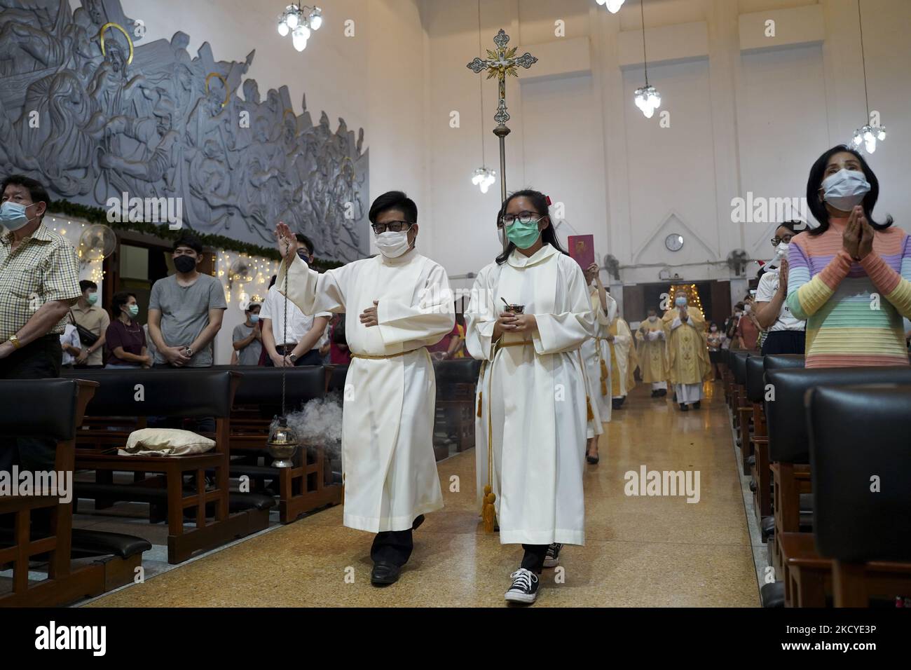 Altarjungen tragen das Kreuz am Heiligabend in einer Kirche in Bangkok, Thailand, 24. Dezember 2021. (Foto von Anusak Laowias/NurPhoto) Stockfoto